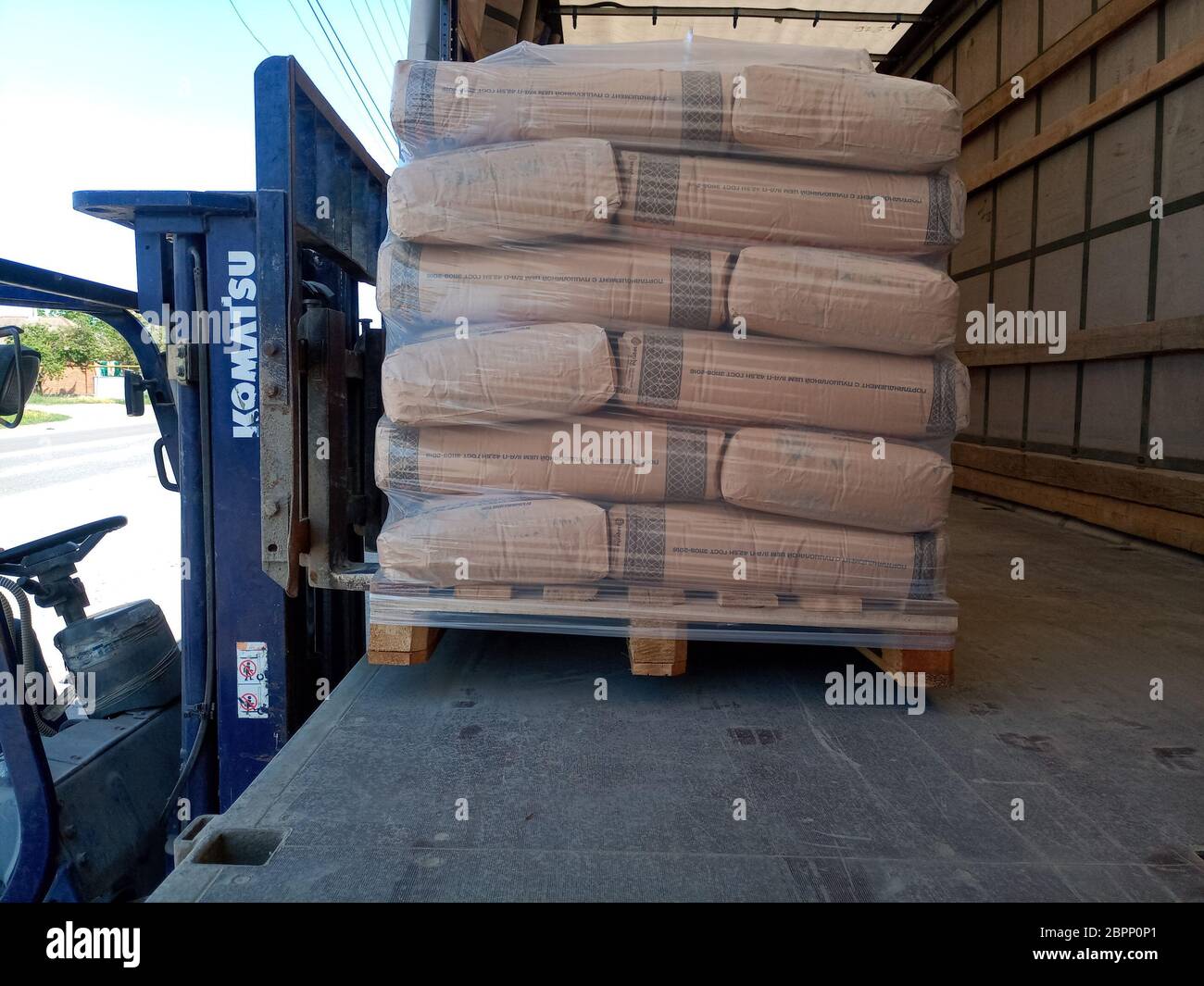 Krasnodar, Russland - 13. Juni 2019: Entladen von Säcken aus Zement von einem LKW mit einem Gabelstapler. Stockfoto
