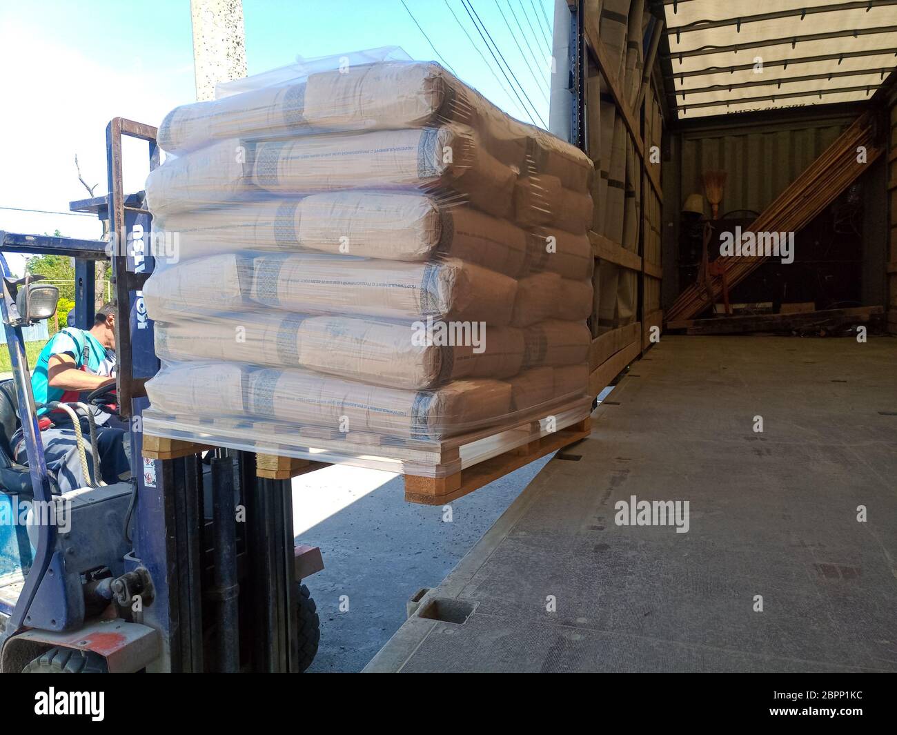 Krasnodar, Russland - 13. Juni 2019: Entladen von Säcken aus Zement von einem LKW mit einem Gabelstapler. Stockfoto