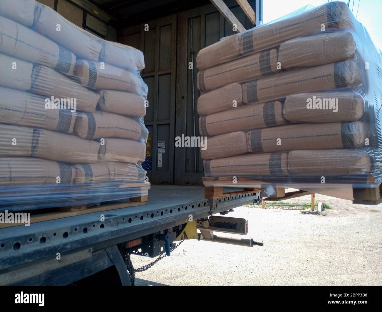 Krasnodar, Russland - 13. Juni 2019: Entladen von Säcken aus Zement von einem LKW mit einem Gabelstapler. Stockfoto