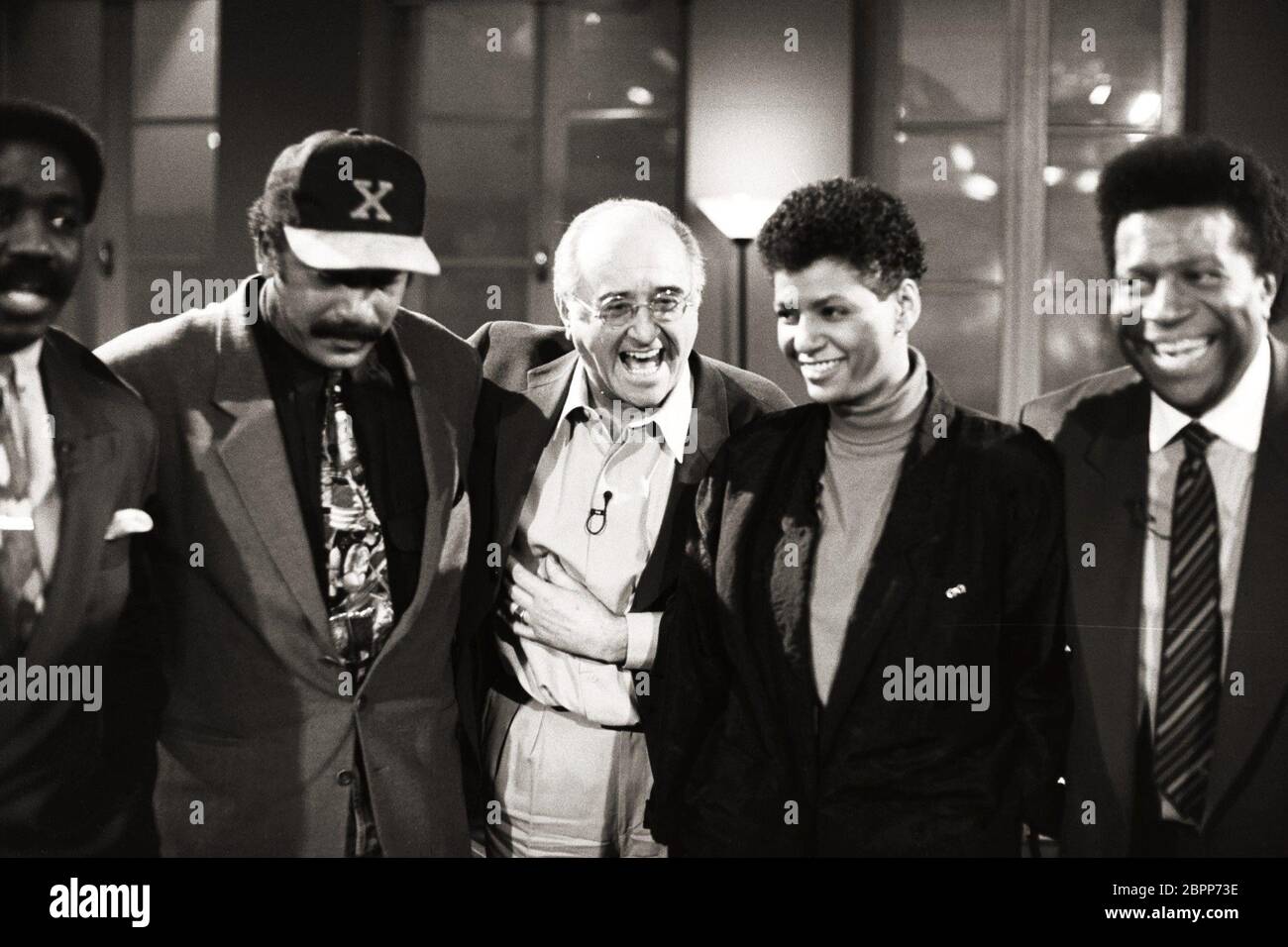 TV-Talkshow Boulevard Bio // 16.12.1992 - auf dem Bild ist der Fernsehproduzent Alfred Biolek (mitte), der Schauspieler Ron Williams (2 v. links) und der Sänger Roberto Blanco (rechts) anderen Gästen in der TV-Talkshow 'Boulevard Bio' After-Show im Wartesaal in den 90ern zu sehen. Stockfoto