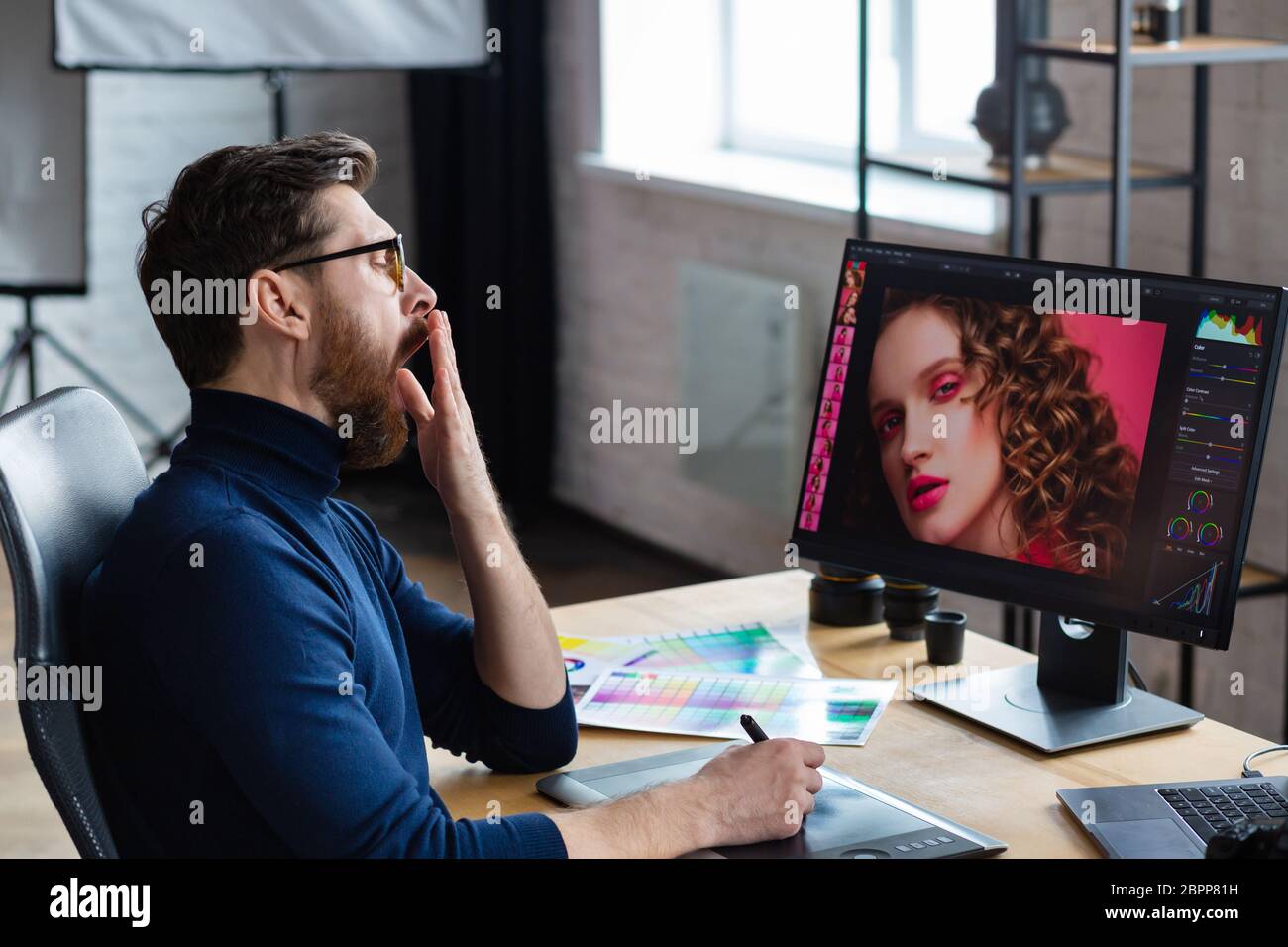 Retusche Bilder in speziellen Programm.Portrait von Grafikdesigner arbeiten im Büro mit Laptop, Monitor, Grafik Zeichnung Tablette und Farbpalette Stockfoto