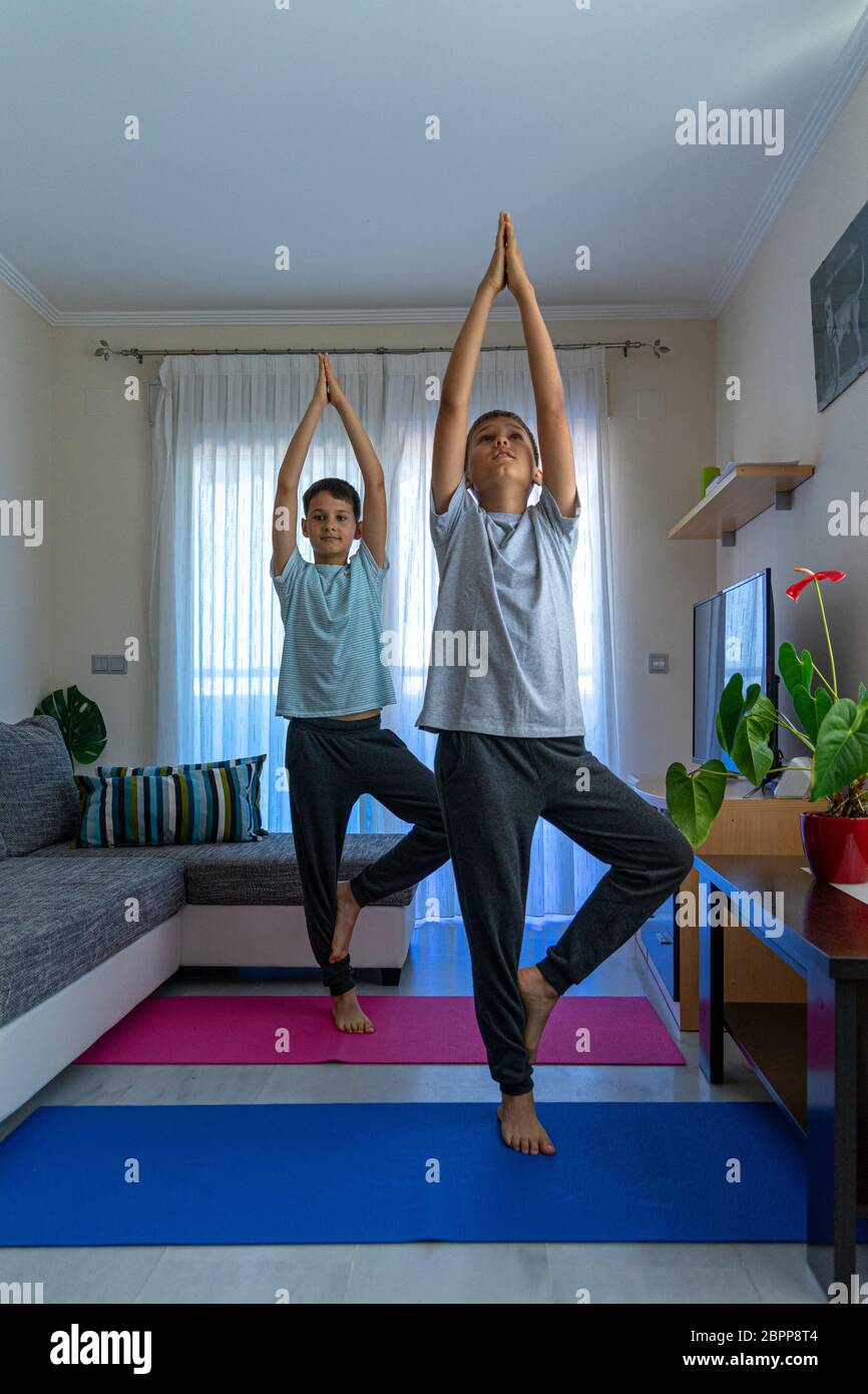 Kinder machen Sportübungen, üben Yoga zu Hause. Sport, gesunder Lebensstil, aktive Freizeit zu Hause Stockfoto