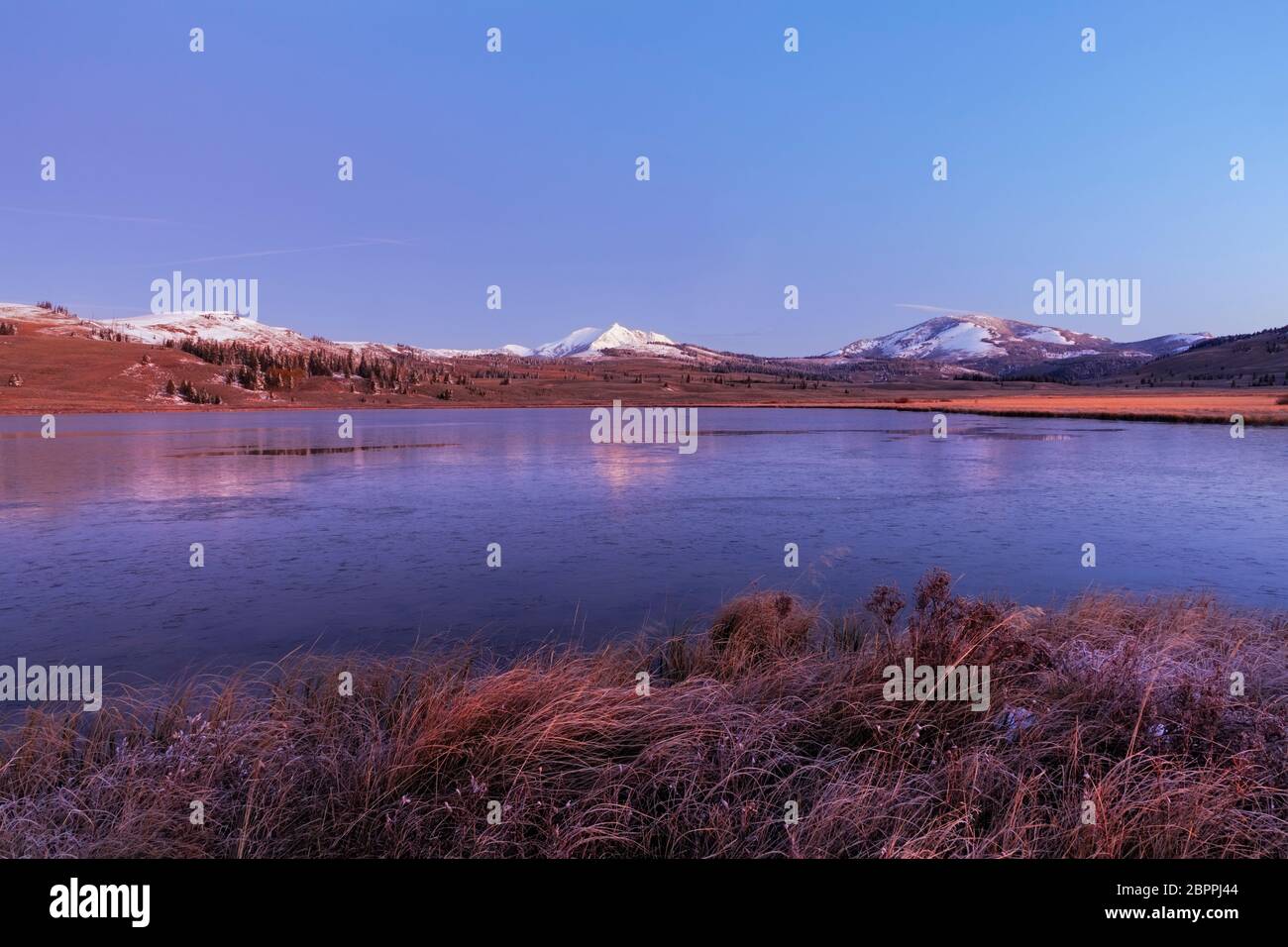 WY04439-00...WYOMING - Herbstaufgang am teilweise gefrorenen Swan Lake mit Gipfeln der Gallatin Range und Bunsen Peak dahinter in Yellowstone Natio Stockfoto