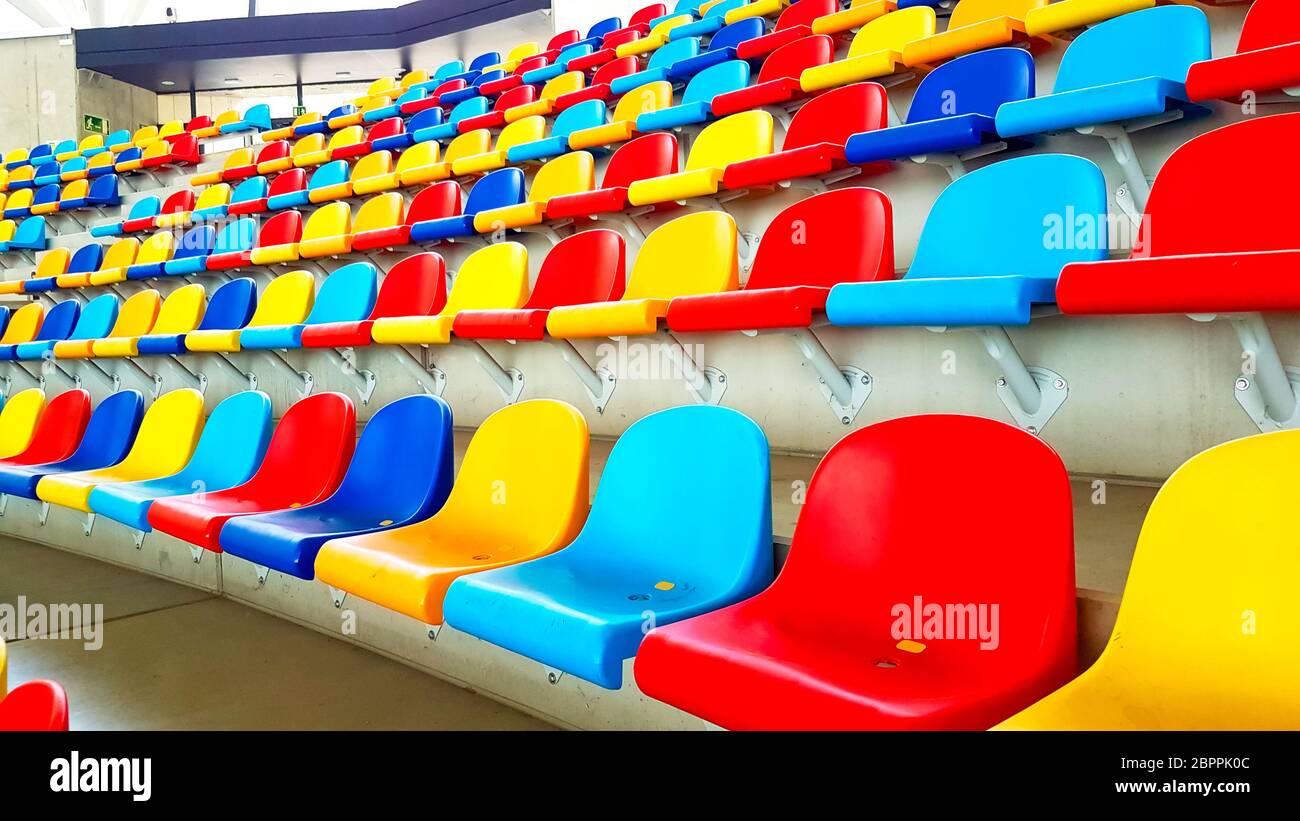 Bunte Bänke in einem leeren Stadion Stockfoto