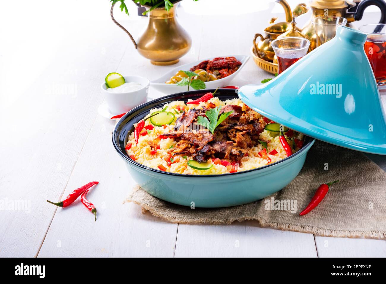 Tajin mit Couscous, Gemüse und Fleisch auf weißem Hintergrund Stockfoto