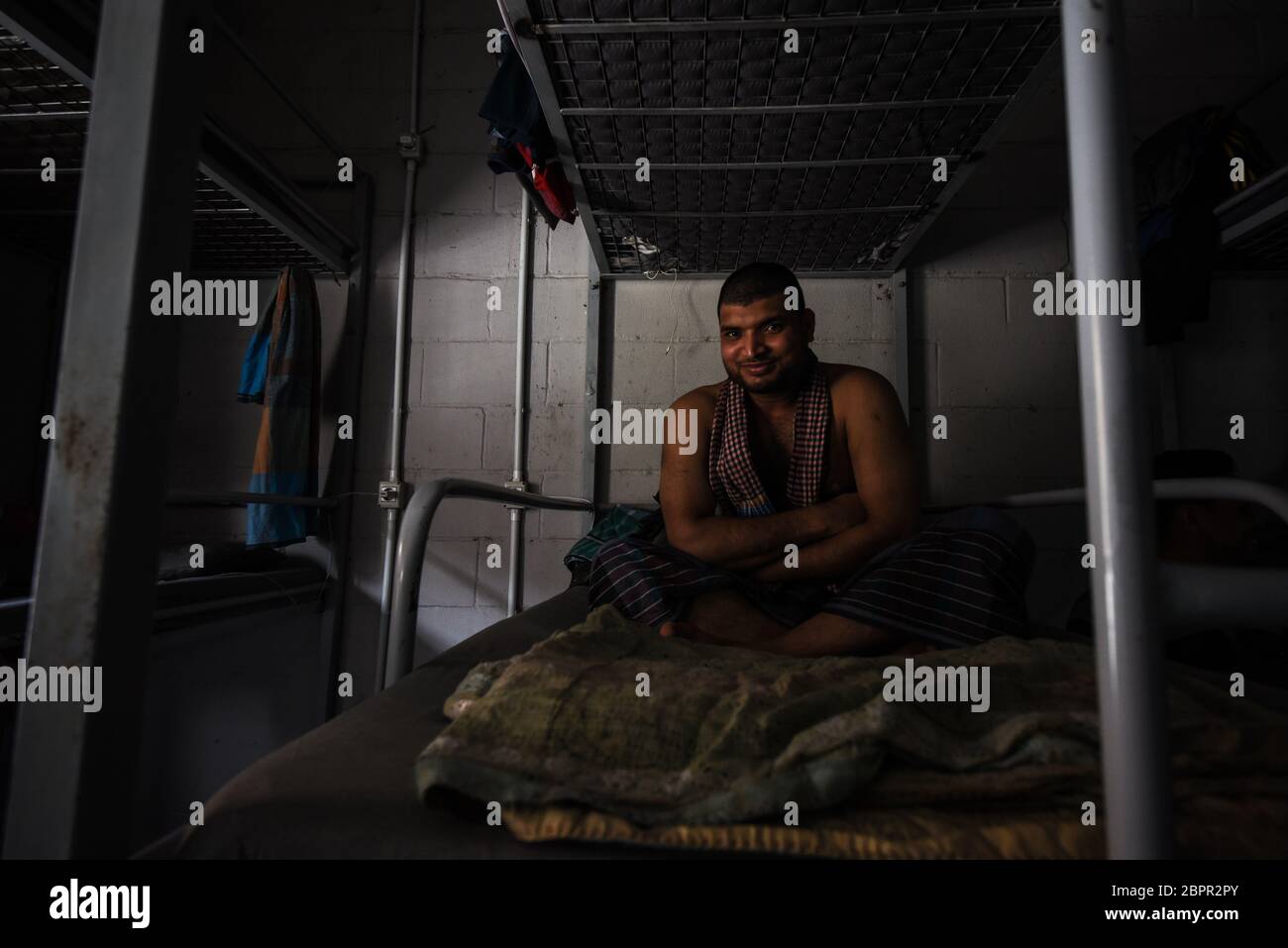 Beirut, Libanon. Mai 2020. Ein Mann sitzt auf seinem Etagenbett im Unterkunftblock für ausländische Arbeitnehmer bei RAMCO Waste Management Credit: Elizabeth Fitt/Alamy Live News Stockfoto