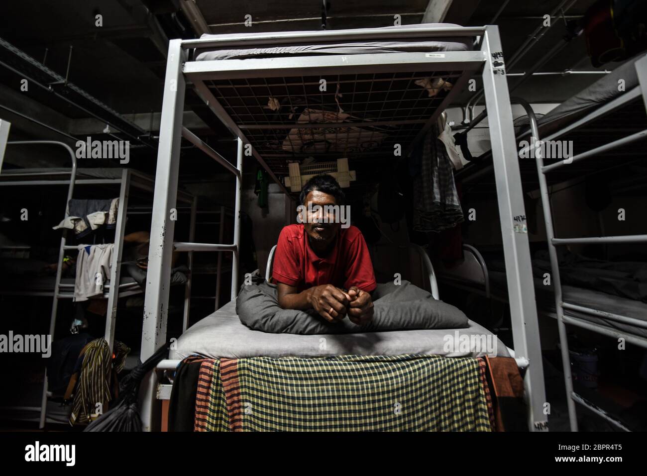Beirut, Libanon. Mai 2020. Ein Mann sitzt auf seinem Etagenbett im Unterkunftblock für ausländische Arbeitnehmer bei RAMCO Waste Management Credit: Elizabeth Fitt/Alamy Live News Stockfoto