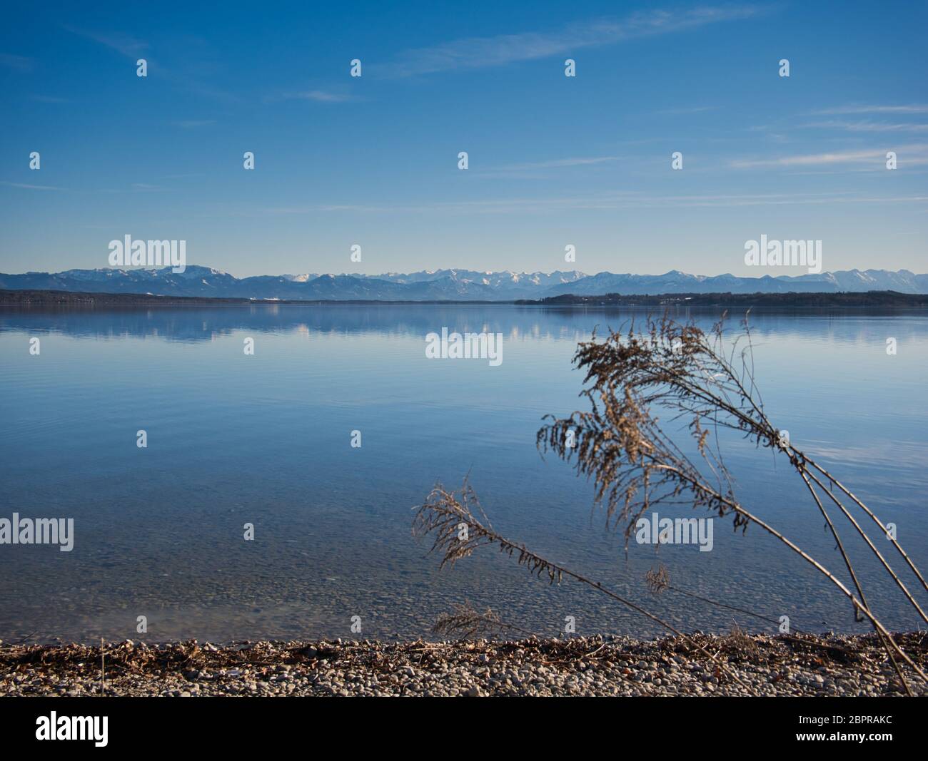 Die Ufer des Starnberger See mit den schneebedeckten Alpen im Hintergrund Stockfoto