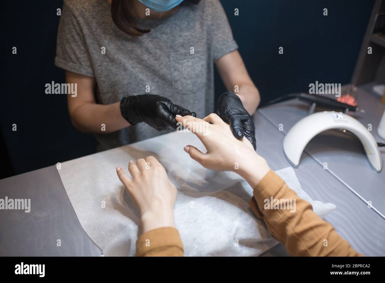 Schönheitssalon, Anwendung feuchtigkeitsspendende Creme auf Client Hände und massieren. Maniküre im Salon. SPA Maniküre, Handmassage und Körperpflege. Nahaufnahme Stockfoto