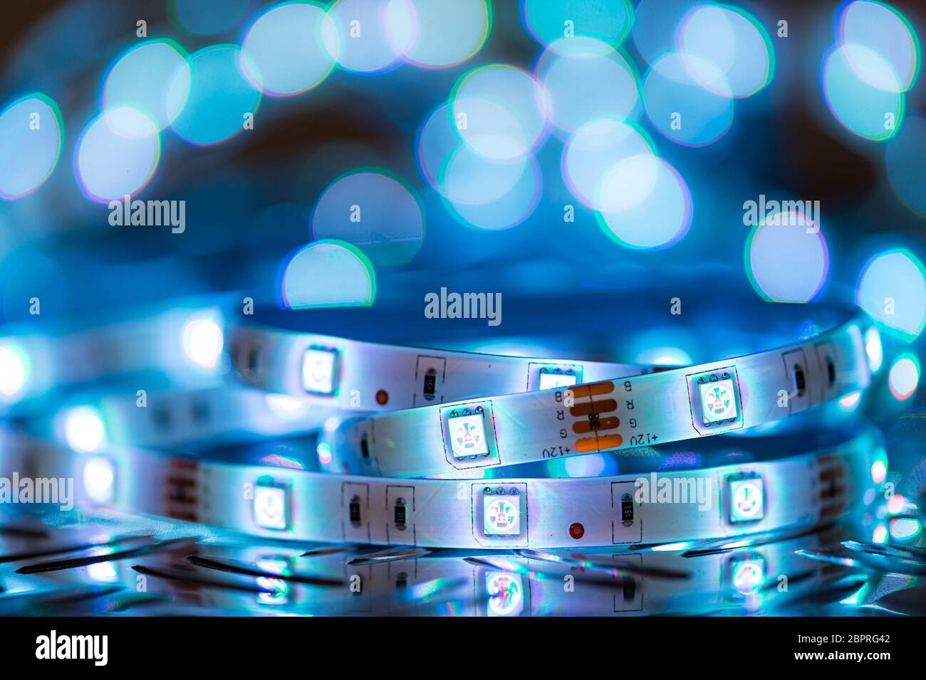 Helle RGB-LED-stripn Licht vor bunten bokeh Metall diamond plate Elektronik Energieeinsparung Dekoration Technik Hintergrund Stockfoto