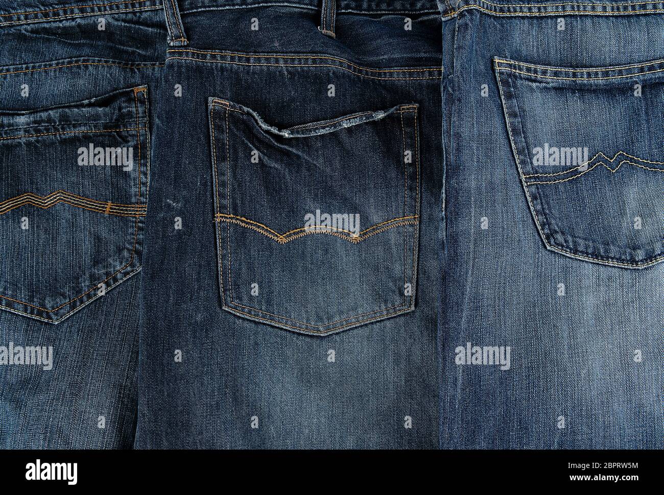 Mehrere andere klassische Jeans in einer Reihe gefaltet, Tasche auf der Rückseite Stockfoto