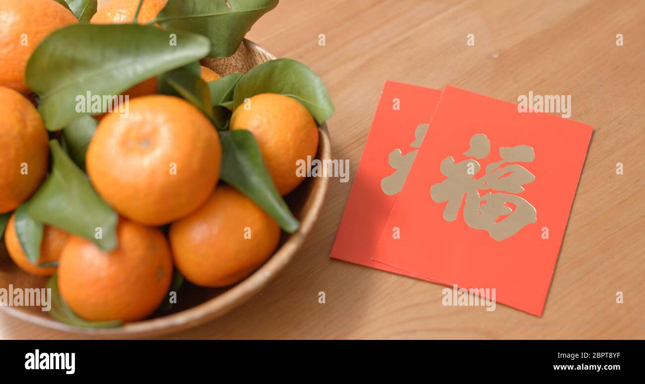 Mandarin orange für Mondneujahr mit rotem Päckchen chinesisches Wort bedeutet Glück Stockfoto