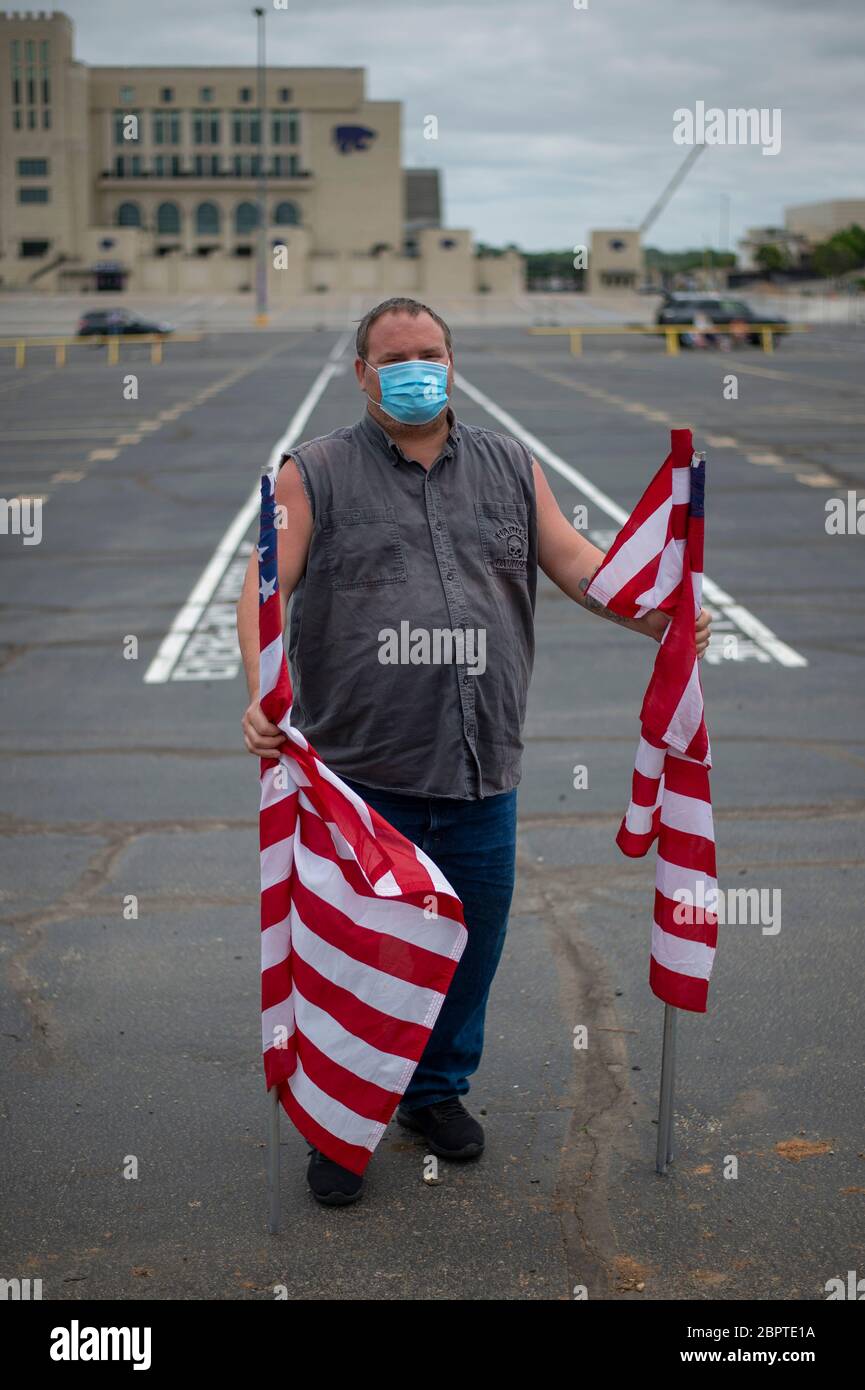 Manhattan, Kansas, USA. Mai 2020. BRAD SCHULTZ, Mitglied der American Legion Post 17, hält am Dienstag amerikanische Flaggen gegenüber dem Ascension Via Christi Hospital. Der 190. Luftbetankungsflügel der Kansas Air National Guard flog um 13:13 Uhr über Manhattan, KS, um Gesundheitsarbeiter, Ersthelfer und andere Frontmitarbeiter im Kampf gegen COVID-19 zu begrüßen. Die Operation Kansas Strong startete in Emporia, KS, und flog über Manhattan, Lawrence und Topeka, KS. Kredit: Luke Townsend/ZUMA Wire/Alamy Live News Stockfoto