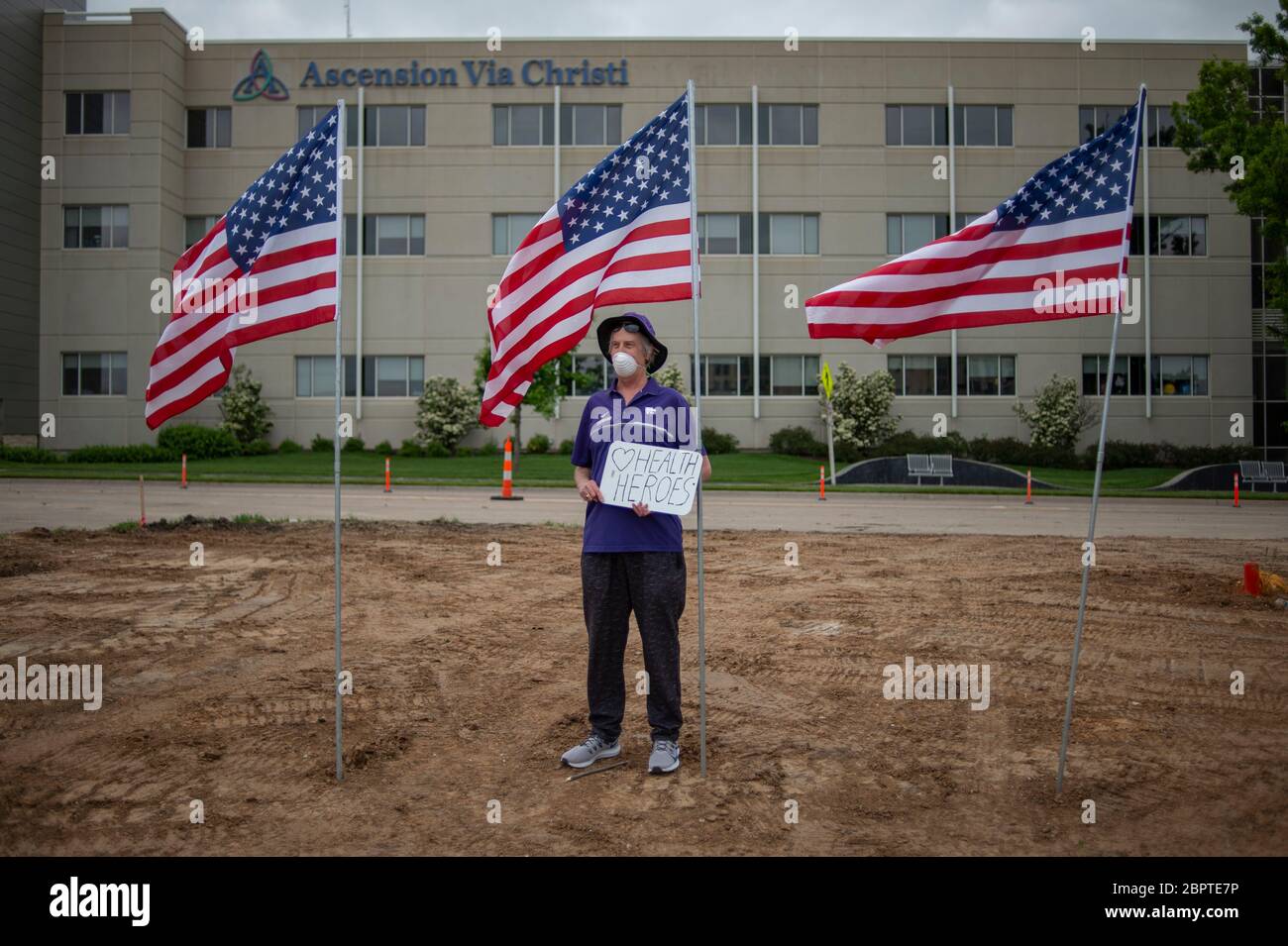 Manhattan, Kansas, USA. Mai 2020. STEVE BREWER, steht gegenüber von Ascension Via Christi Hospital mit einem Schild, das lautet, Health Heroes, machte zu danken lokalen Gesundheitshelfer am Dienstag. Der 190. Luftbetankungsflügel der Kansas Air National Guard flog um 13:13 Uhr über Manhattan, KS, um Gesundheitsarbeiter, Ersthelfer und andere Frontmitarbeiter im Kampf gegen COVID-19 zu begrüßen. Die Operation Kansas Strong startete in Emporia, KS, und flog über Manhattan, Lawrence und Topeka, KS. Kredit: Luke Townsend/ZUMA Wire/Alamy Live News Stockfoto