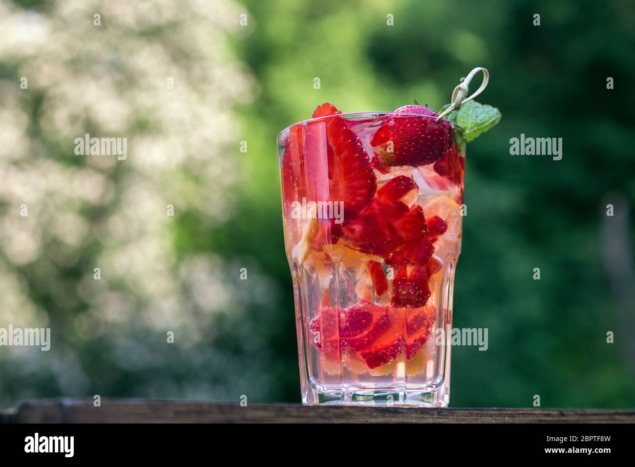 Ein frischer alkoholfreier Cocktail aus Obst und Beeren im Sommer. Saftige Erdbeere mit Apfel und Minze mit Eis Stockfoto