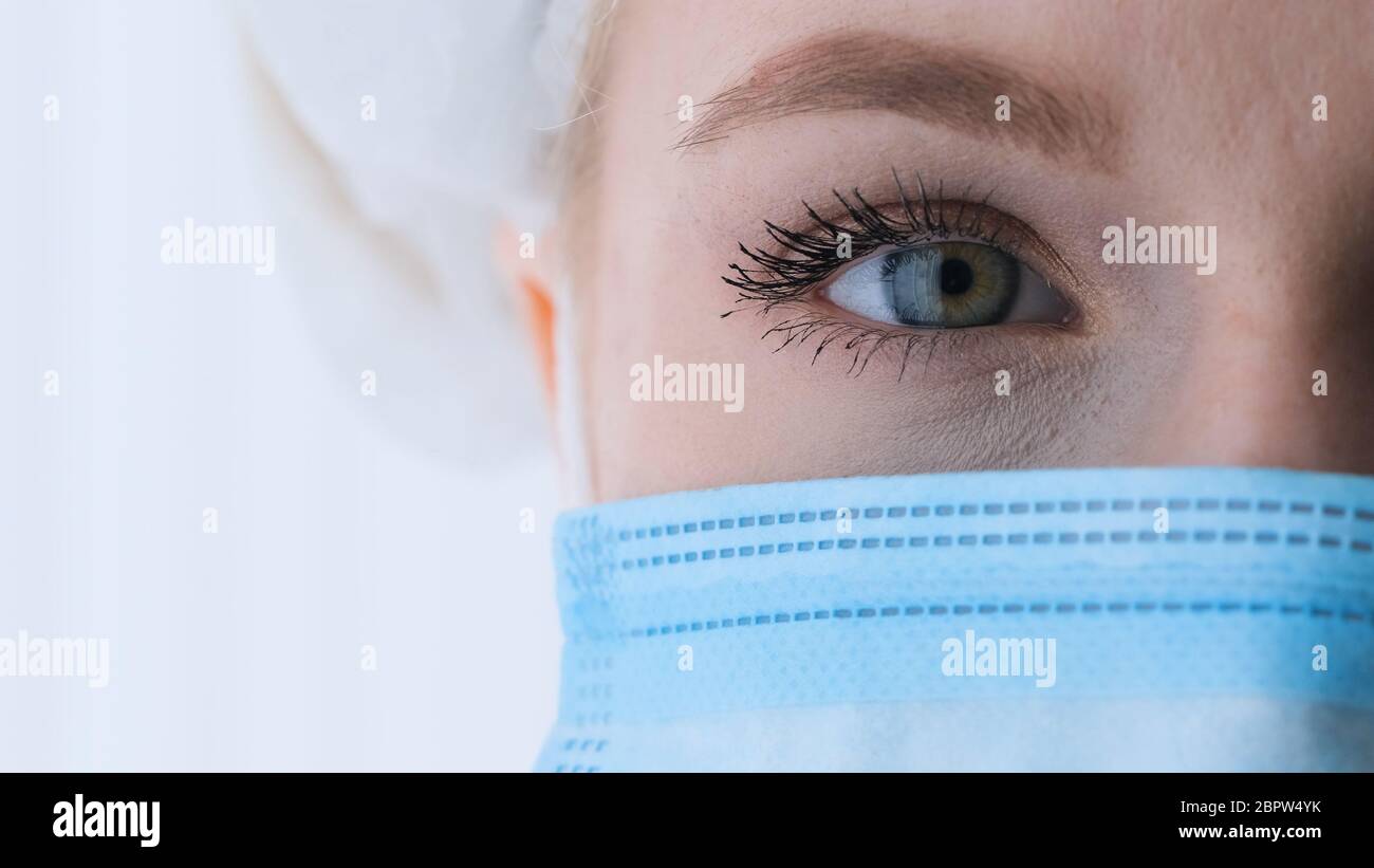 Nahaufnahme Porträt von erfahrenen kaukasischen Chirurgen, Arzt mit schützender blauer Maske und weißer Kappe bereit, in einem Krankenhaus oder einer Klinik zu arbeiten. Auge o Stockfoto