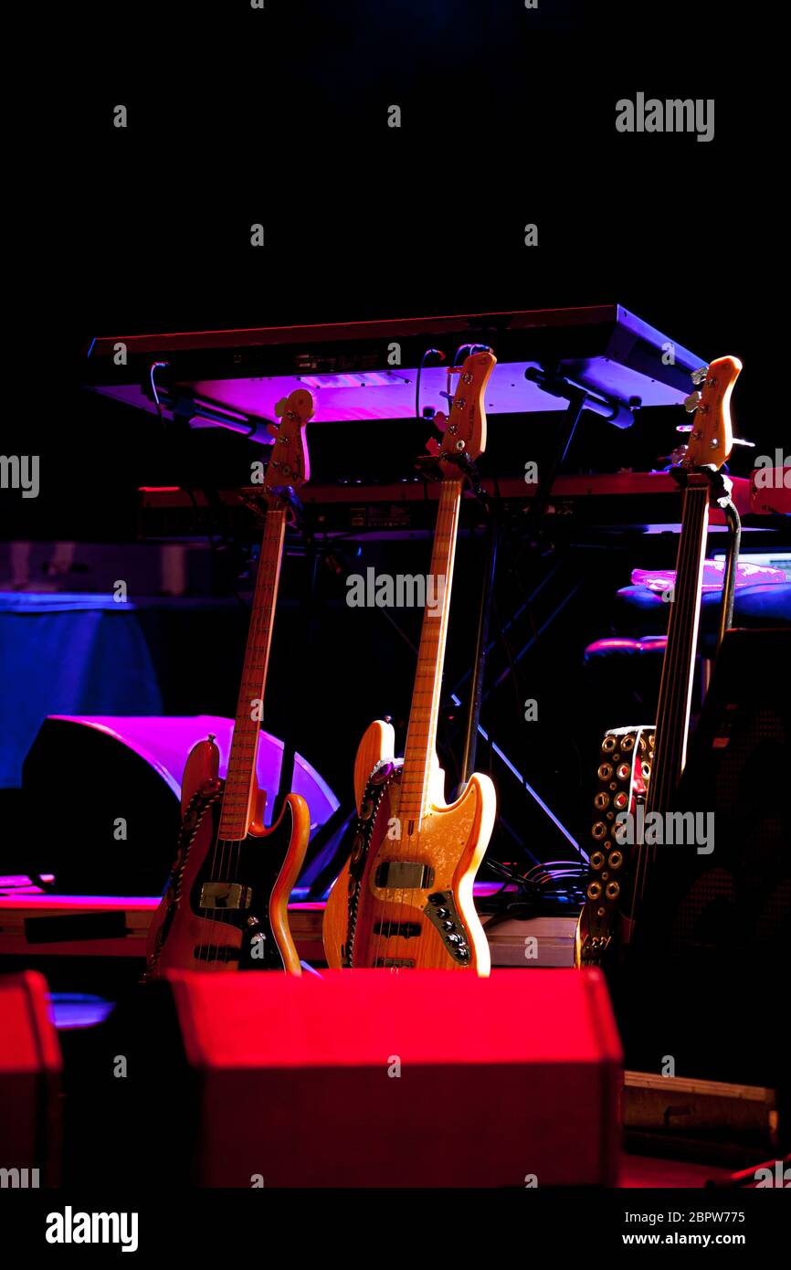 Bass-Gitarren und Keyboard auf einer Bühne in mehrfarbigem Bühnenlicht vor dem Beginn eines Jazzkonzerts Stockfoto