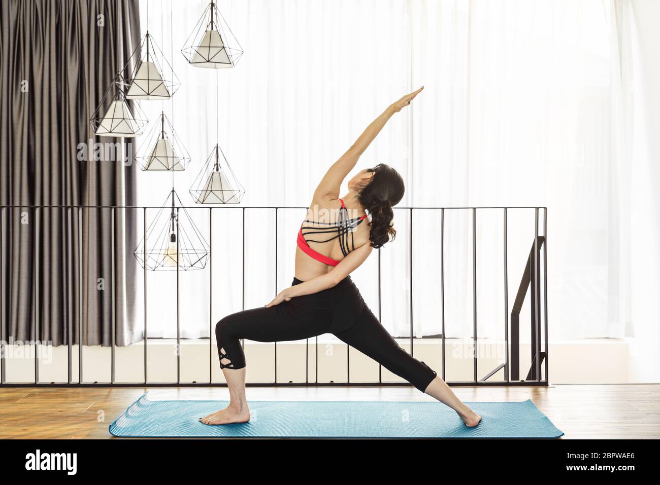 Asiatische Frau Yoga von zu Hause aus, wenn Covid19 Ausbruch und Lockdown, gesunde oder Meditation Übung, Yoga-Training zu Hause, Coronavirus Pandemie A Stockfoto