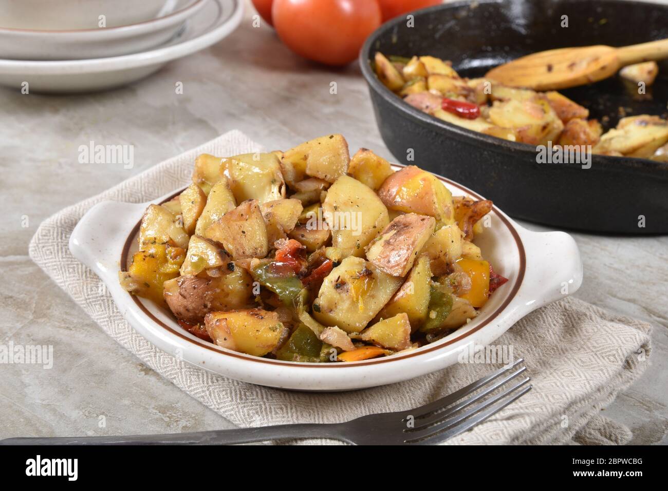 Ein Gericht aus gerösteten Kartoffelkeilen mit roten und grünen Paprika Stockfoto