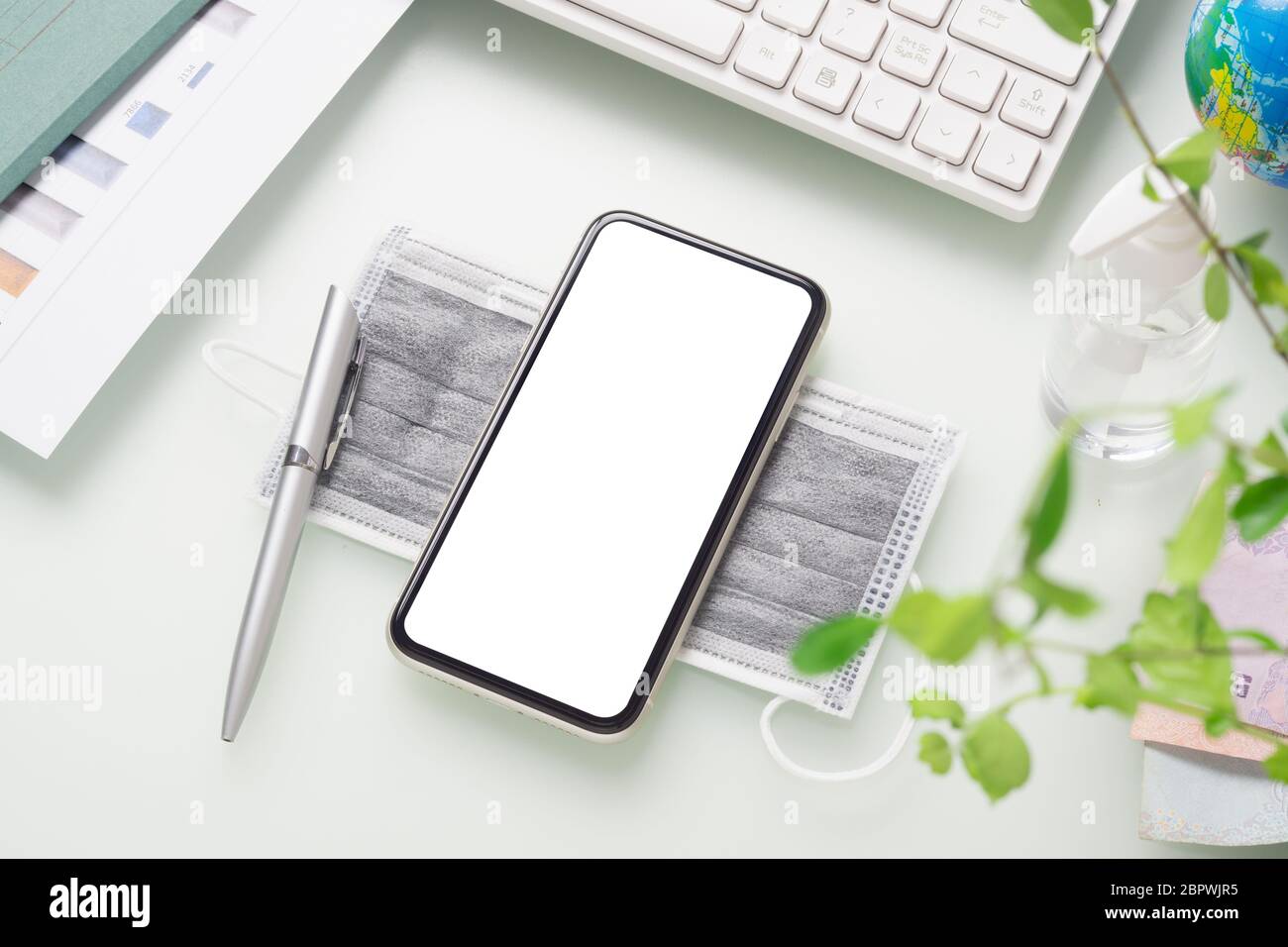 Mockup-Mobiltelefon für Covid 19 Business Impact Background Concept. Mockup weißen leeren Bildschirm Smartphone für Ihre Kunstwerke mit Gesichtsmasken und Alcoh Stockfoto