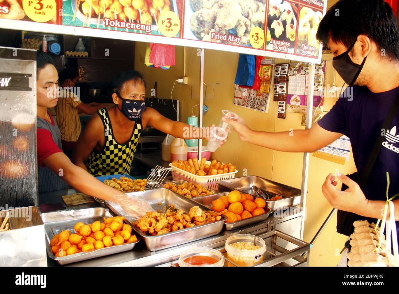 Antipolo City, Philippinen - 16. Mai 2020: Verkäufer serviert verschiedene frittierte Speisen an seinem Stand als Quarantäne Regeln gelockert nach einem zwei Monate erweiterte comm Stockfoto