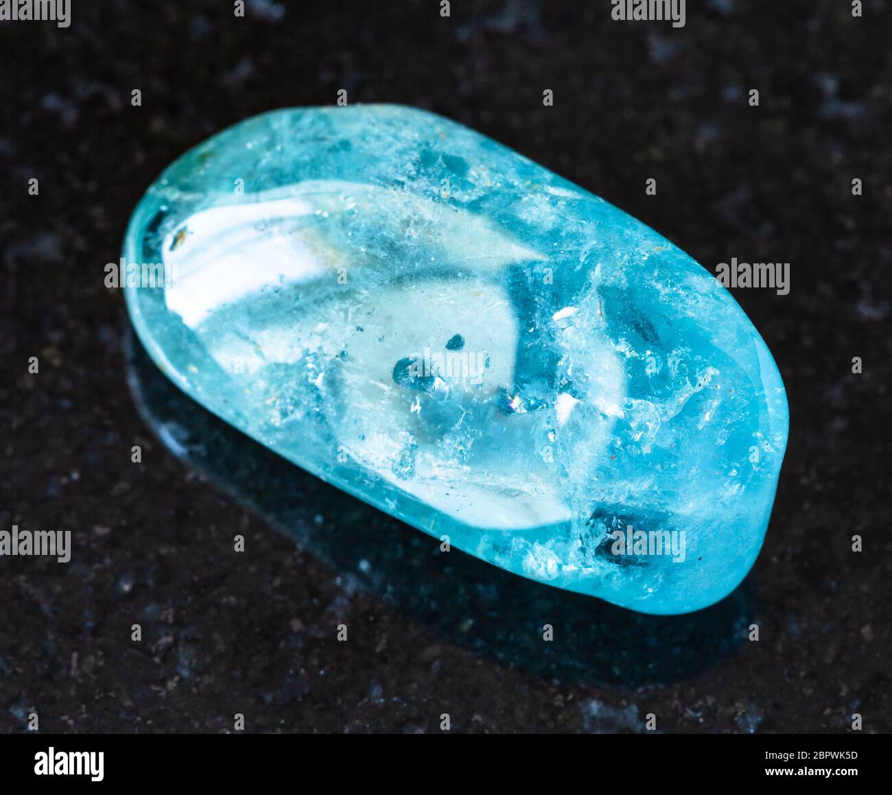 Nahaufnahme der Probe von natürlichen Mineral aus geologischer Sammlung - gestürzte Aquamarin (blau Beryl) Gestein auf schwarzem Granit Hintergrund aus Brasilien Stockfoto