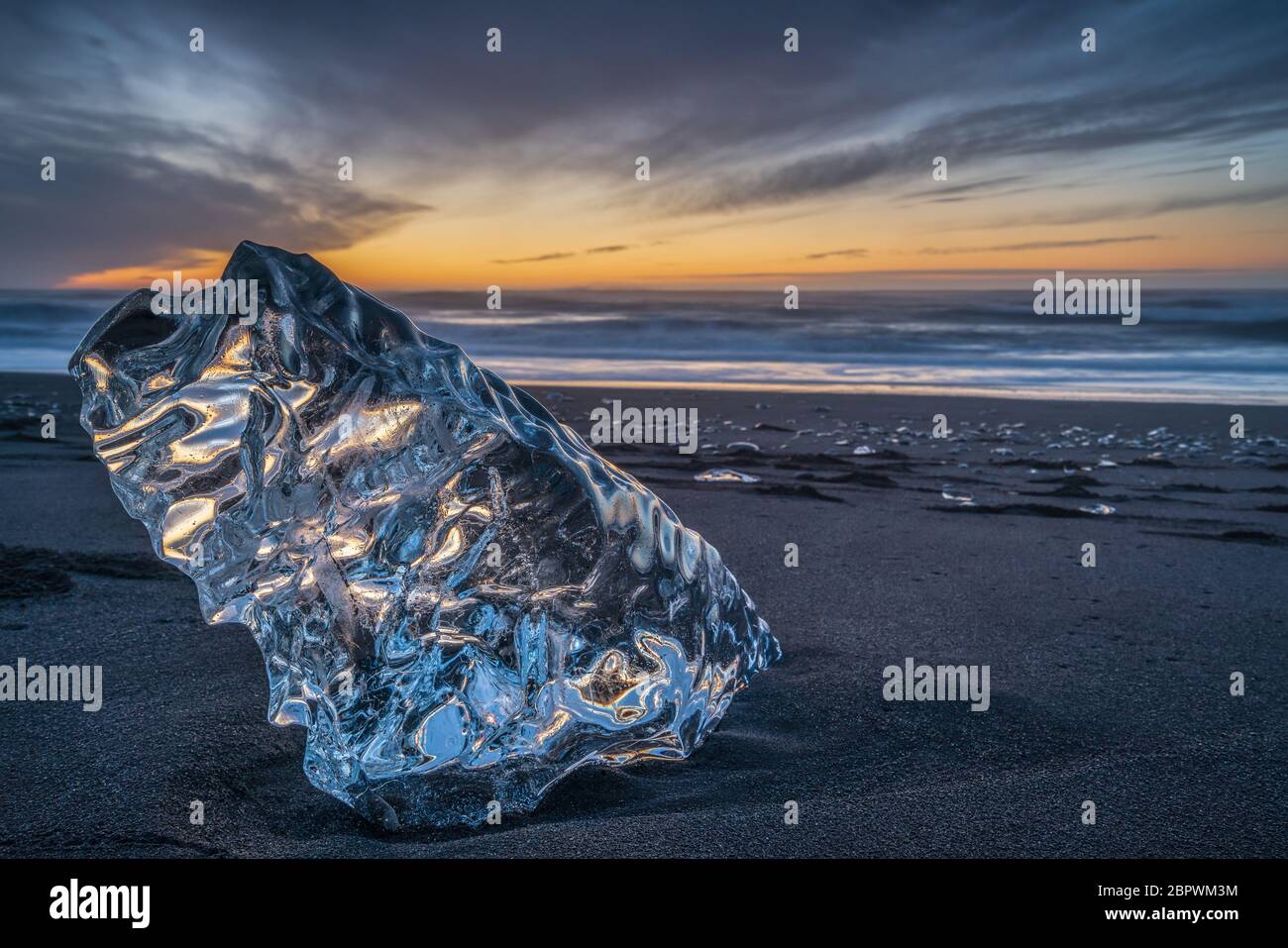 Ein großer Eisblock am Strand bei Sonnenaufgang, in der Nähe der Jokulsarlon Lagune in Südisland, auch Diamond Beach genannt Stockfoto