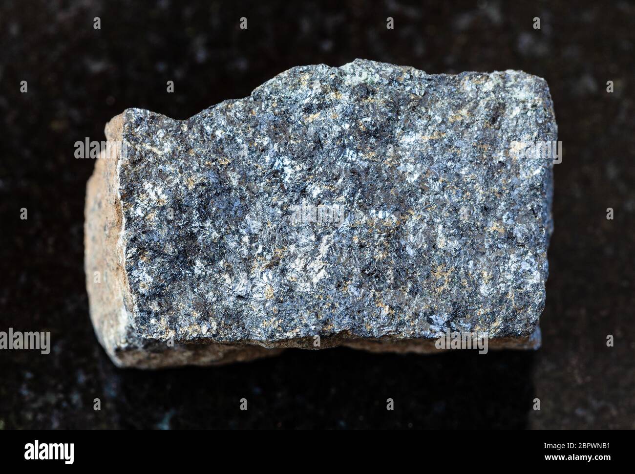 Nahaufnahme der Probe von natürlichen Mineralien aus geologischer Sammlung - unpoliertes Zinkerz (Sphalerit) Gestein auf schwarzem Granit Hintergrund aus Süd-Karelien Stockfoto
