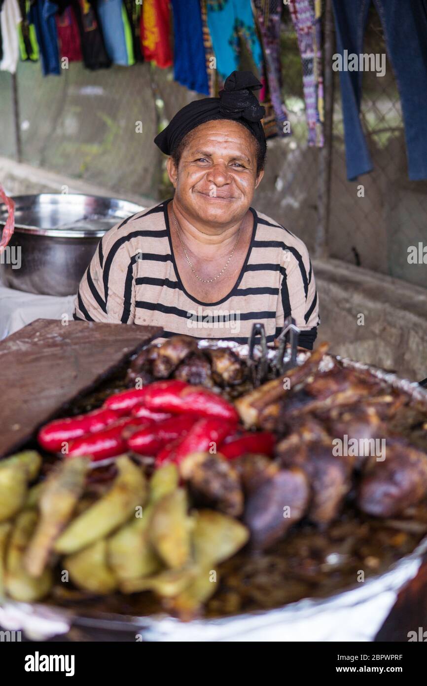 Port Moresby / Papua Neuguinea: Frau lächelt an einem Straßenstand mit gegrilltem Fleisch Stockfoto