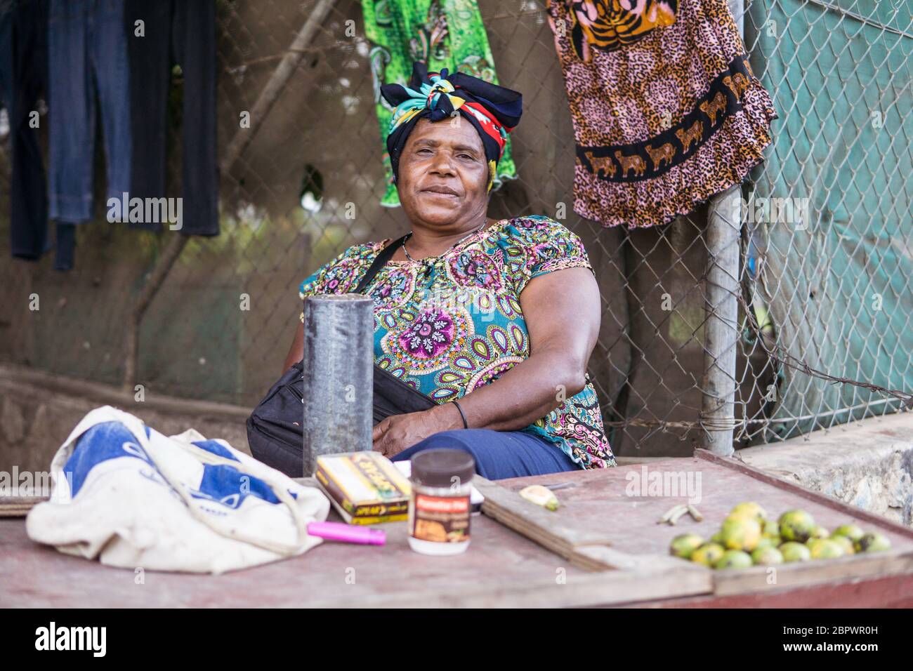 Port Moresby / Papua Neuguinea: Große Frau mit bunten Kleidern, die Betelnüsse, Areca-Nüsse verkauft, an einem Straßenstand außerhalb von Port Moresby Stockfoto