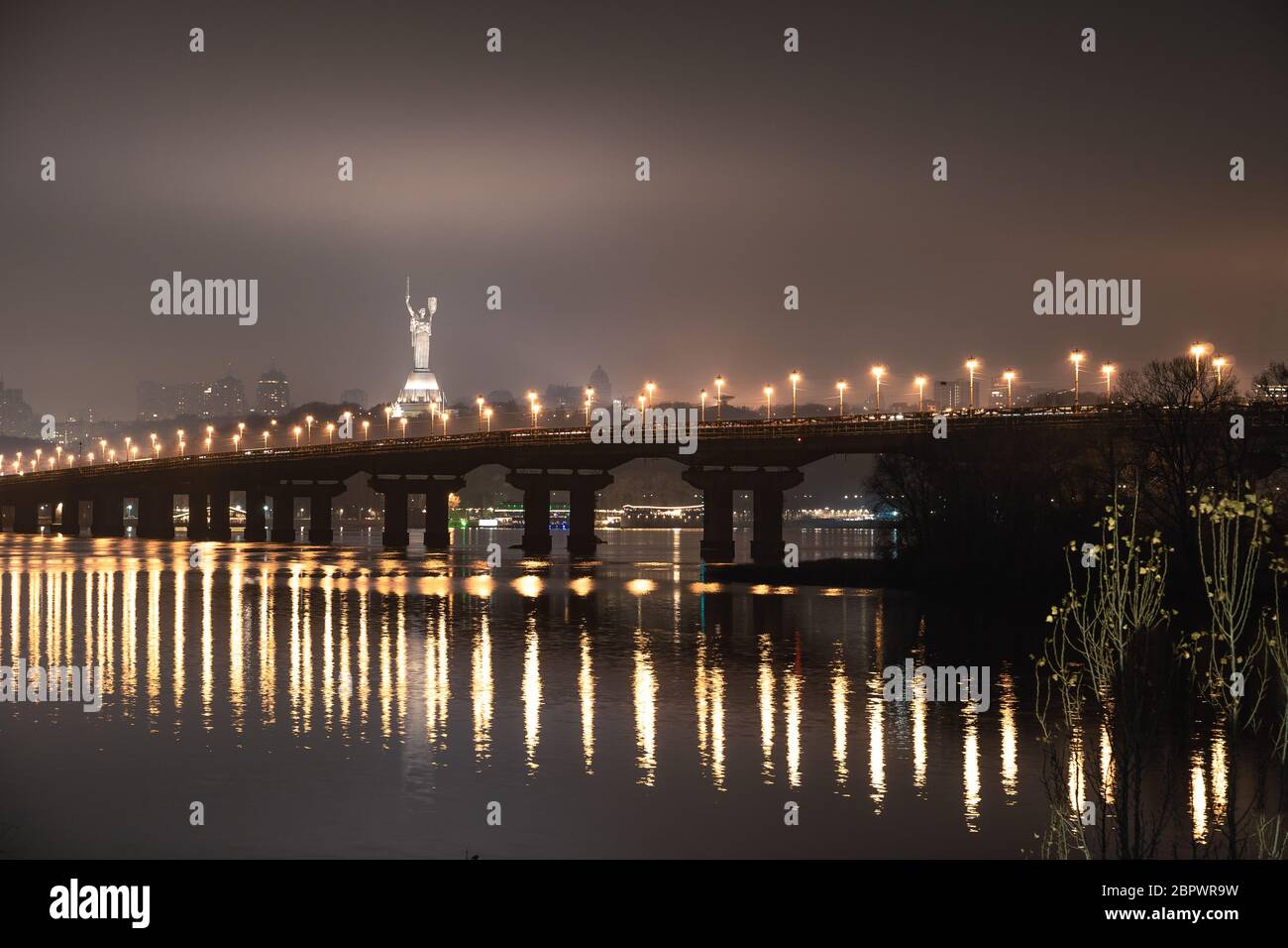 Nachtansicht der Brücke über den breiten Fluss Dnipro in Kiew auf einer langen Belichtung Stockfoto