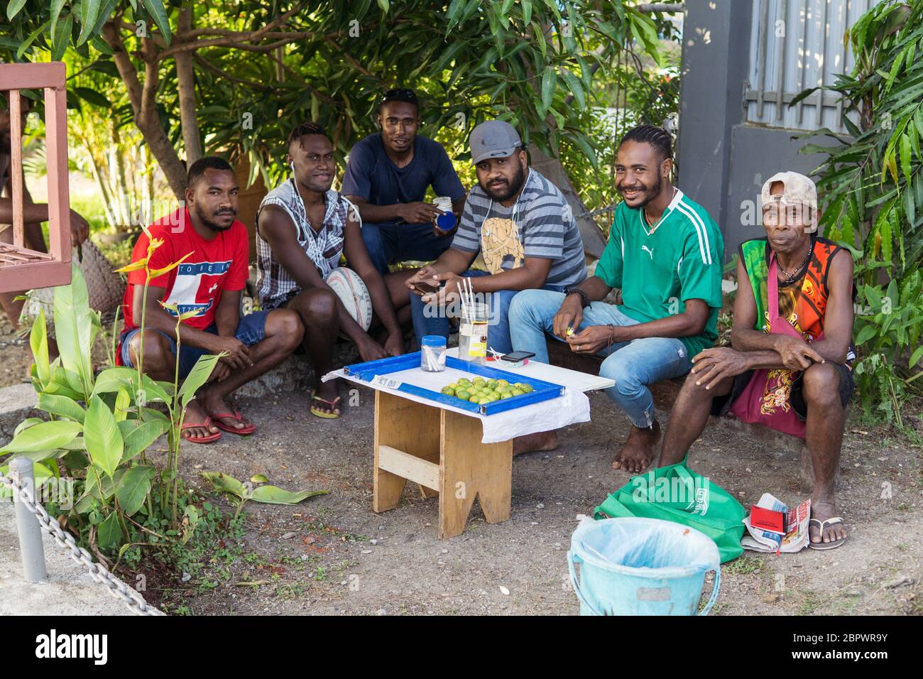 Port Moresby / Papua-Neuguinea: Eine Gruppe von Männern, die Betelnüsse, Areca-Nüsse, an einem Straßenstand außerhalb von Port Moresby verkaufen und konsumieren Stockfoto