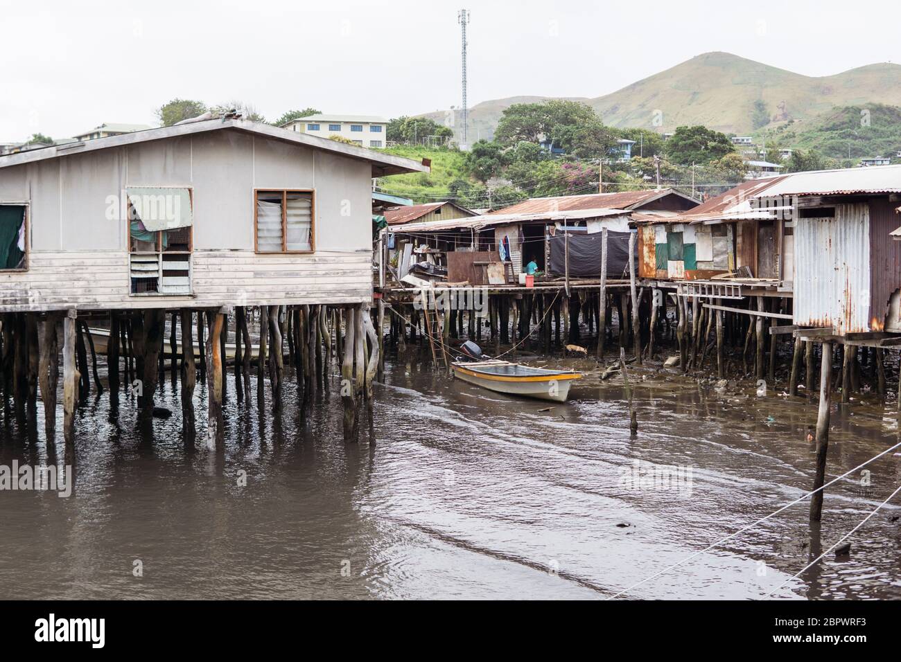 Port Moresby / Papua Neuguinea: Holzhäuser über dem Wasser in einem schwimmenden Dorf mit Kindern auf der Veranda Stockfoto