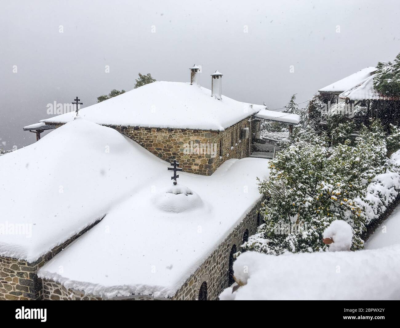 Ein anomales Phänomen auf dem heiligen Berg Athos, fiel Schnee und bedeckte grüne Bäume Stockfoto