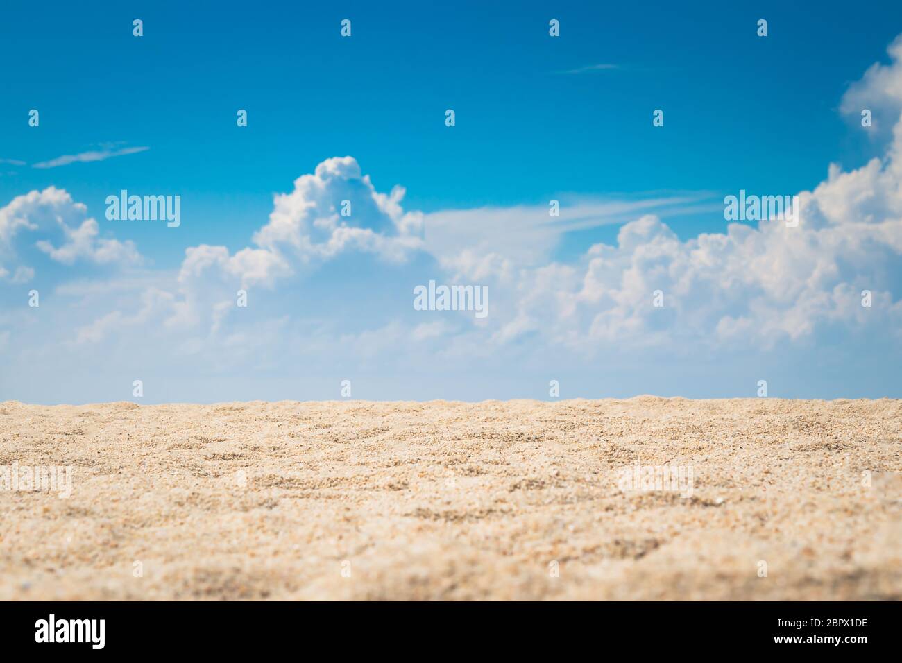 Blick auf den leeren tropischen Sandstrand mit einer geschwollenen weißen Wolke und blauem Himmel Hintergrund Stockfoto