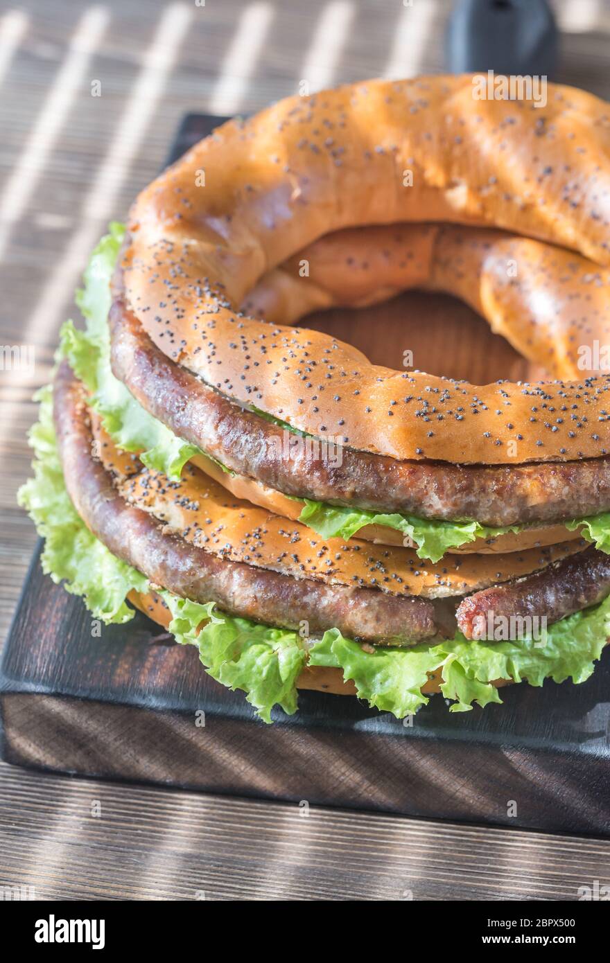 Bagels mit frischem Salat und gebratene Würstchen Stockfoto