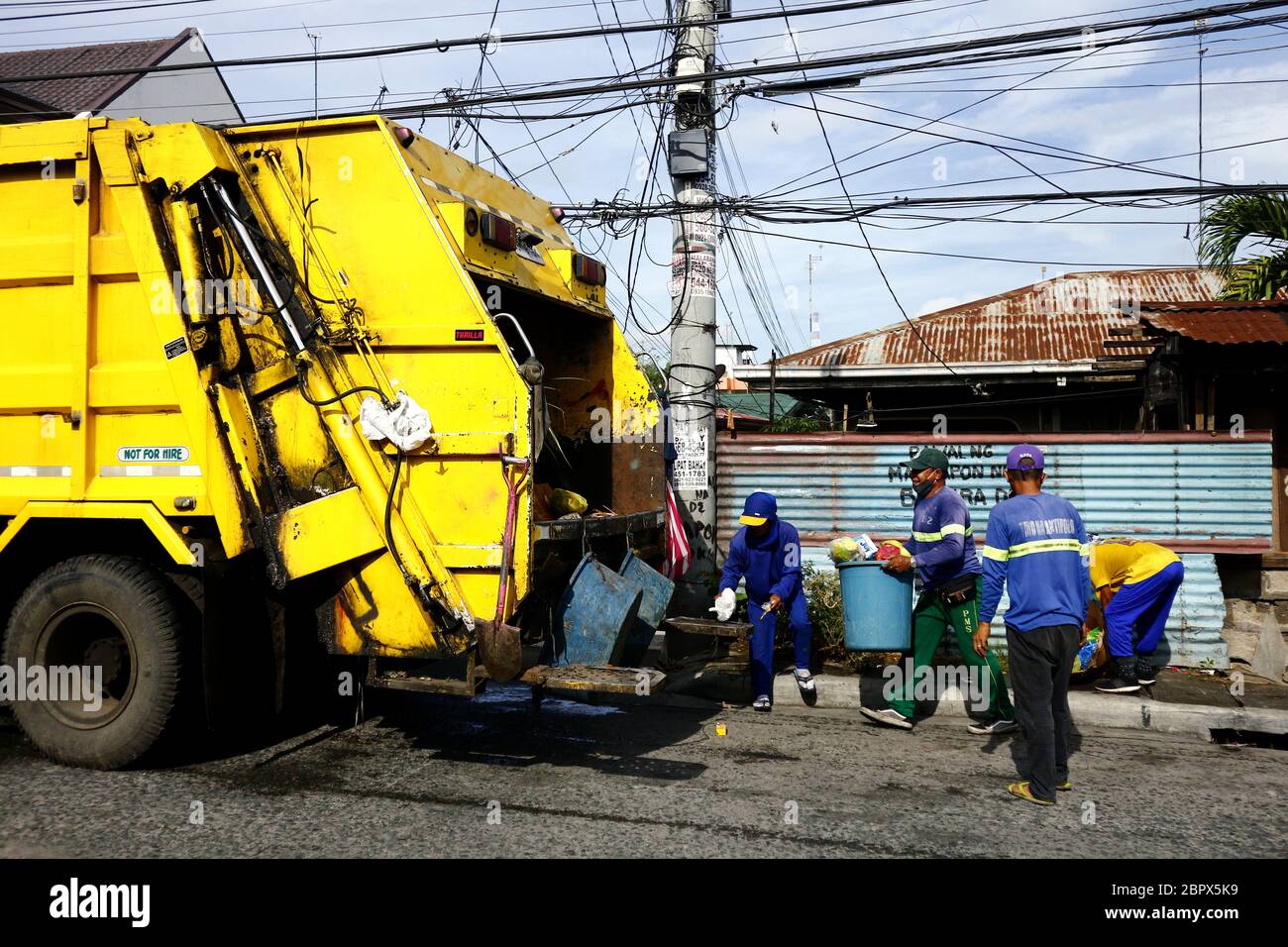 Antipolo City, Philippinen - 16. Mai 2020: Müllsammler legen Müll und Müll auf einen Müllwagen. Stockfoto