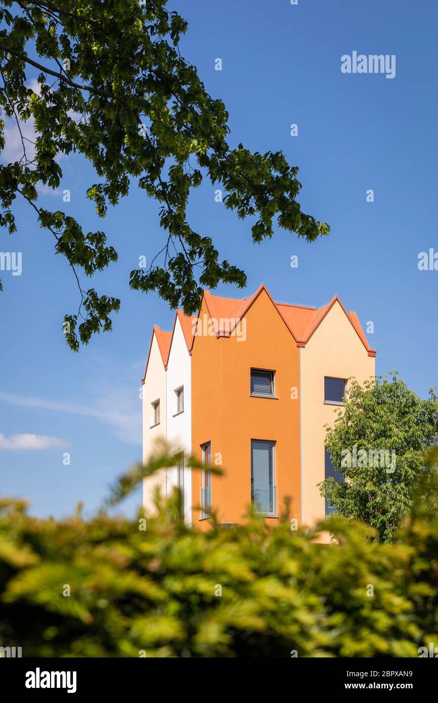 Moderne kleine Wohnhäuser, die auf anderen Häusern in den Niederlanden gebaut werden. Warme farbige Fassaden in verschiedenen Schattierungen. Geometrischer Architekt Stockfoto