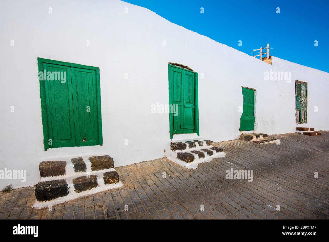 Typische Kanarische Häuser mit grünen Türen oder Fenstern in Teguise auf der Insel Lanzarote, Kanarische Inseln, Spanien Stockfoto