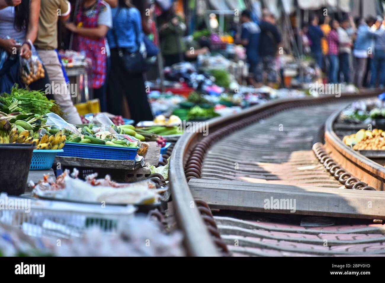 Verkauf von Speisen auf der Maeklong Railway Markt in Thailand. Stockfoto