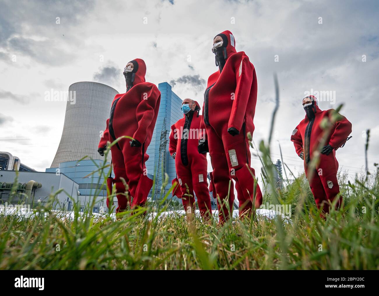 Datteln, Deutschland. Mai 2020. Greenpeace-Aktivisten in roten Neoprenanzügen stehen vor dem Kohlekraftwerk Datteln 4 und schwammen dann mit einem Banner im angrenzenden Dortmund-Ems-Kanal. Das Kohlekraftwerk im nördlichen Ruhrgebiet ist zum Symbol der energiepolitischen Debatte der Bundesregierung geworden. Das Kraftwerk des Düsseldorfer Energieunternehmens Uniper soll im Sommer endgültig ans Netz gehen. Der Betreiber Uniper hat eine Online-Einladung zu seiner Hauptversammlung am 20.05.2020 erteilt. Quelle: Bernd Thissen/dpa/Alamy Live News Stockfoto