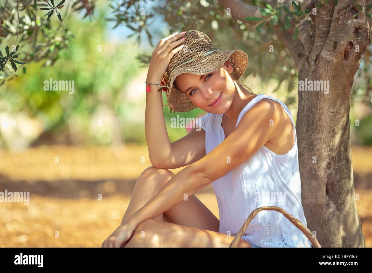 Schöne junge Frau sitzt und ruhen unter dem Baum im Garten, schöne warmen Frühlingstag, Freizeitgestaltung im Freien, glücklich Frühling ho Stockfoto