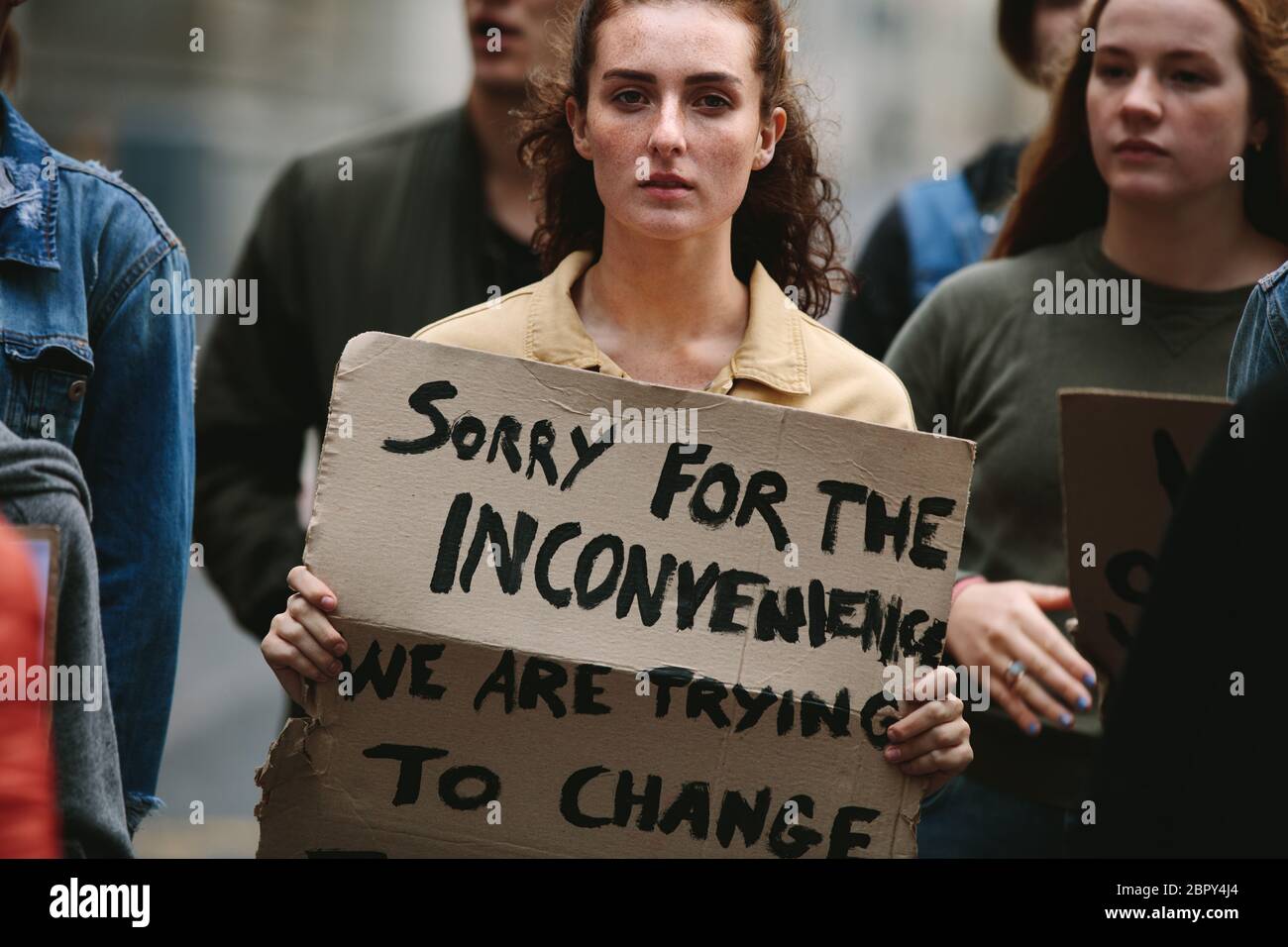 Frau protestiert mit einer Gruppe von Menschen auf der Straße. Eine Gruppe von Aktivisten marschiert und protestiert in der Stadt. Stockfoto
