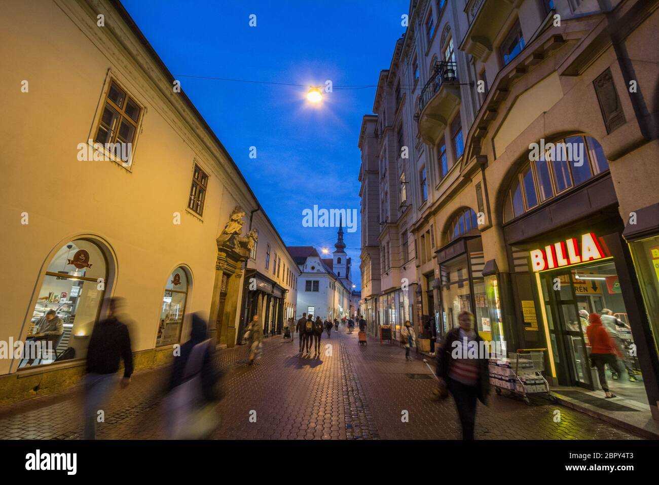 BRNO, TSCHECHIEN - 5. NOVEMBER 2019: Frantiskanske ulice Straße im Stadtzentrum von Brno, umgeben von Boutiquen, bei Nacht, mit Kostel svate mari mag Stockfoto