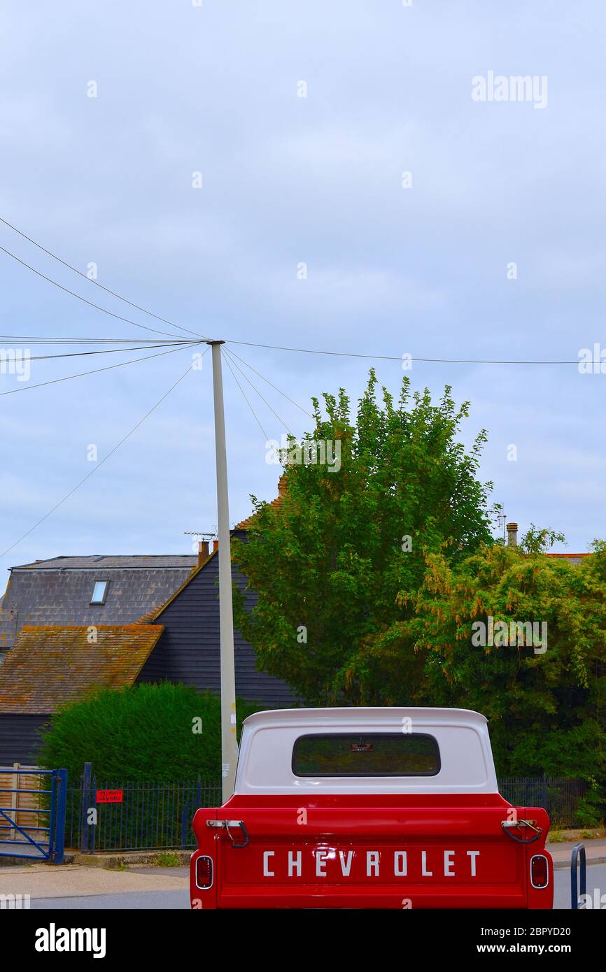 Ein klassisches Retro rot-weiß Chevrolet Pick-up-Truck Vintage Allradantrieb Fahrzeug Chevy vor traditionellen englischen Kent County Häuser geparkt Stockfoto