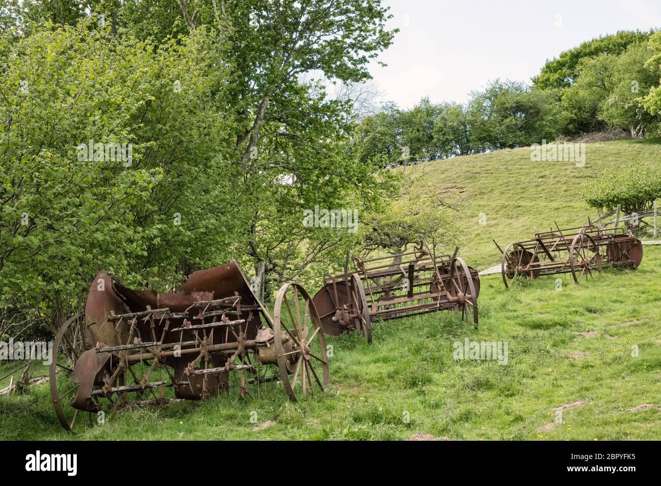 Alte Landmaschinen rosten auf einem Feld an der walisischen Grenze in der Nähe von Knighton, Powys, Wales, Großbritannien Stockfoto