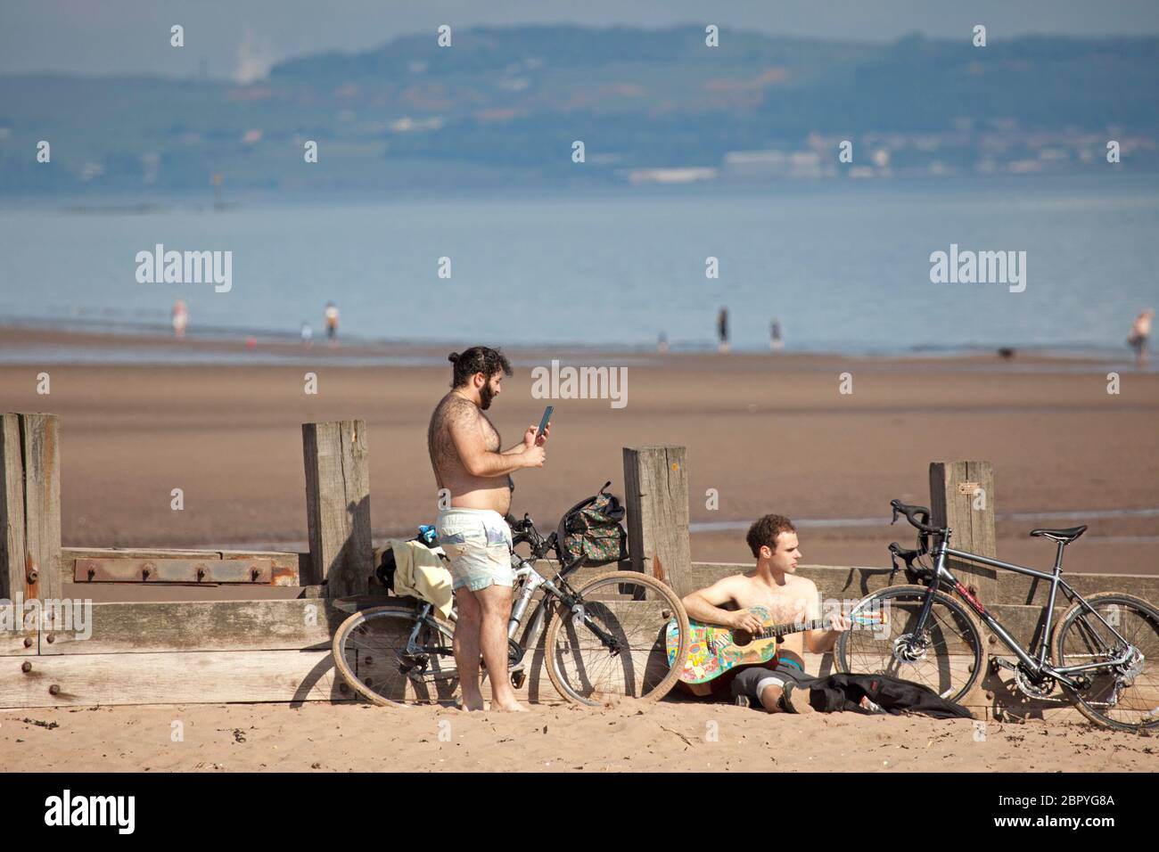 Portobello.Edinburgh, Schottland, Großbritannien. 20 Mai 2020. Ruhiger Start heiß sonnig und 18 Grad Celsius vor 10 Uhr. Zwei Jungs, einer mit Gitarre, legen sich für eine Sonnenbad Session. Stockfoto