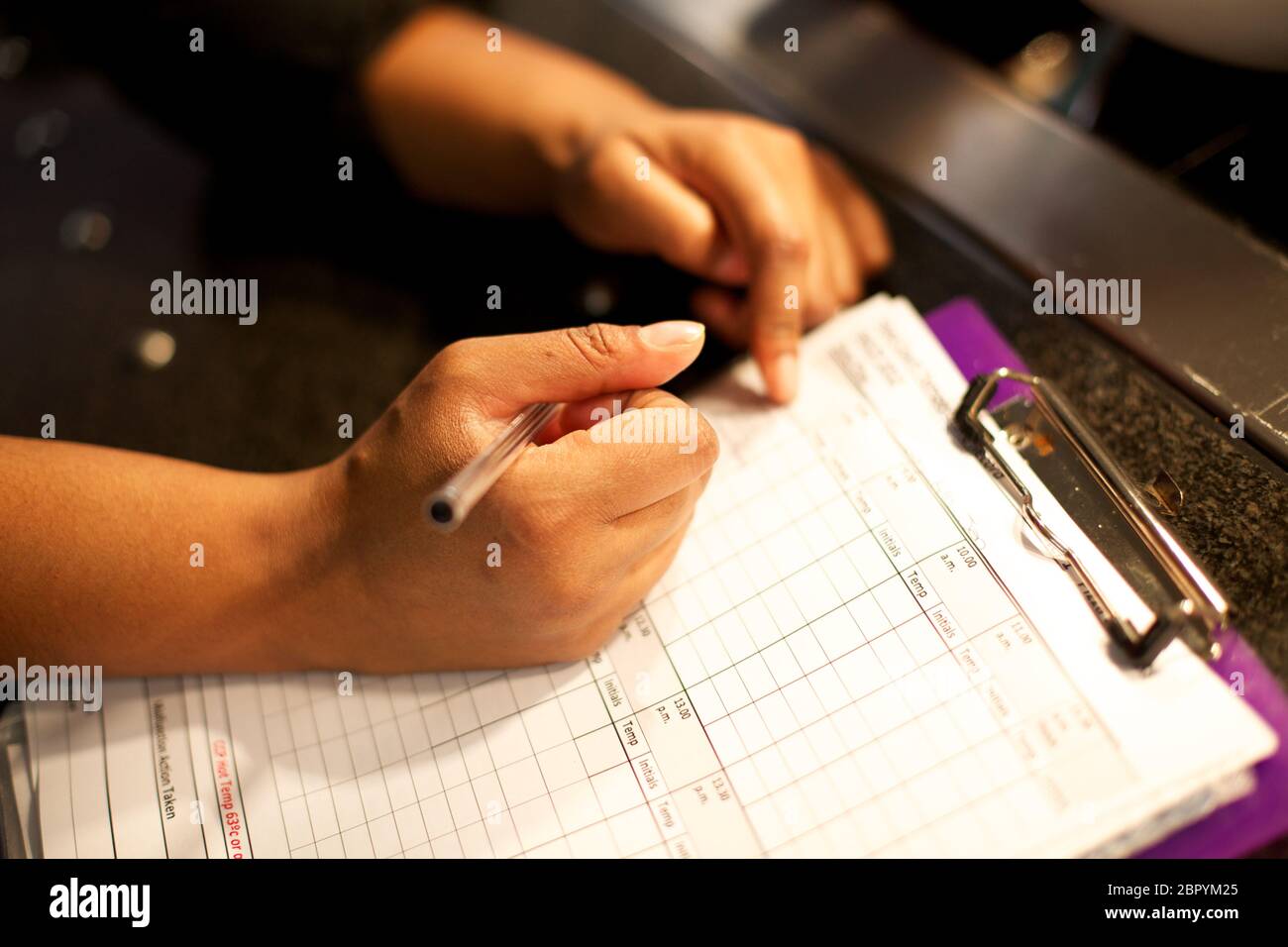 Der Koch schreibt die Temperaturen der Kühlschränke auf die Temperaturliste  auf Stockfotografie - Alamy