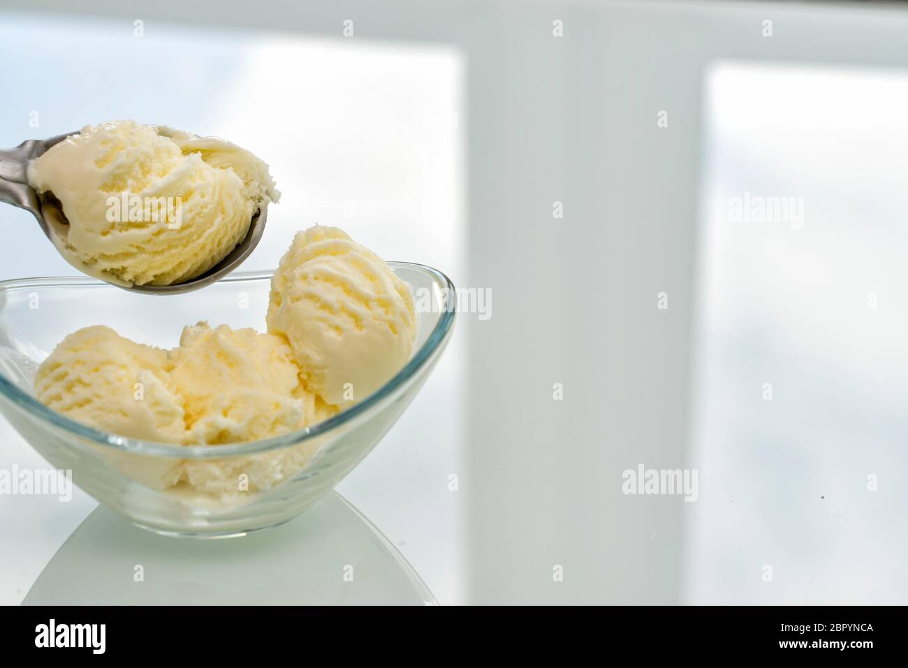 Eine Kugel Eis wird in eine Glasschüssel, Platz für Text gelegt Stockfoto