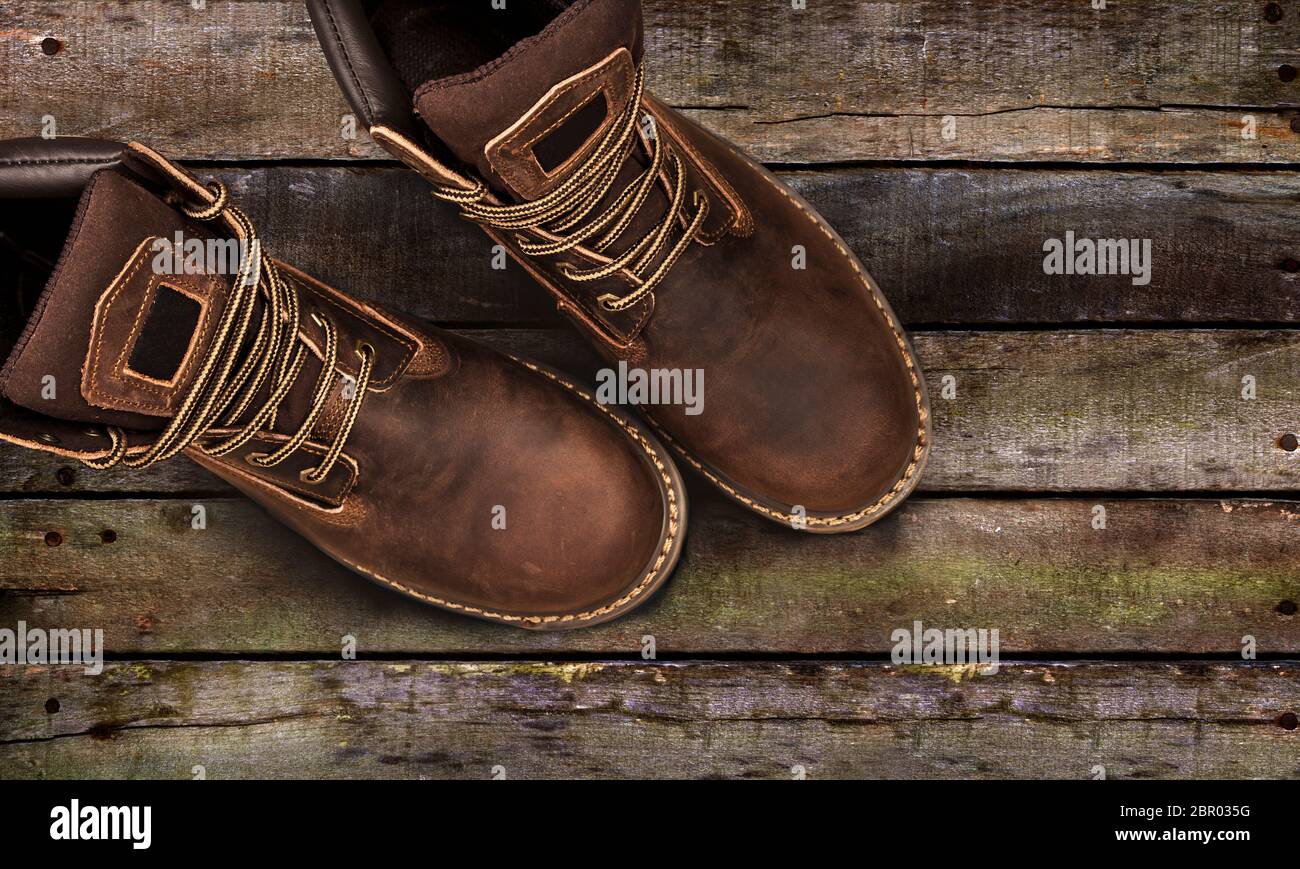 Braun Herren stiefel, auf einer hölzernen Hintergrund. Closeup isoliert Stockfoto